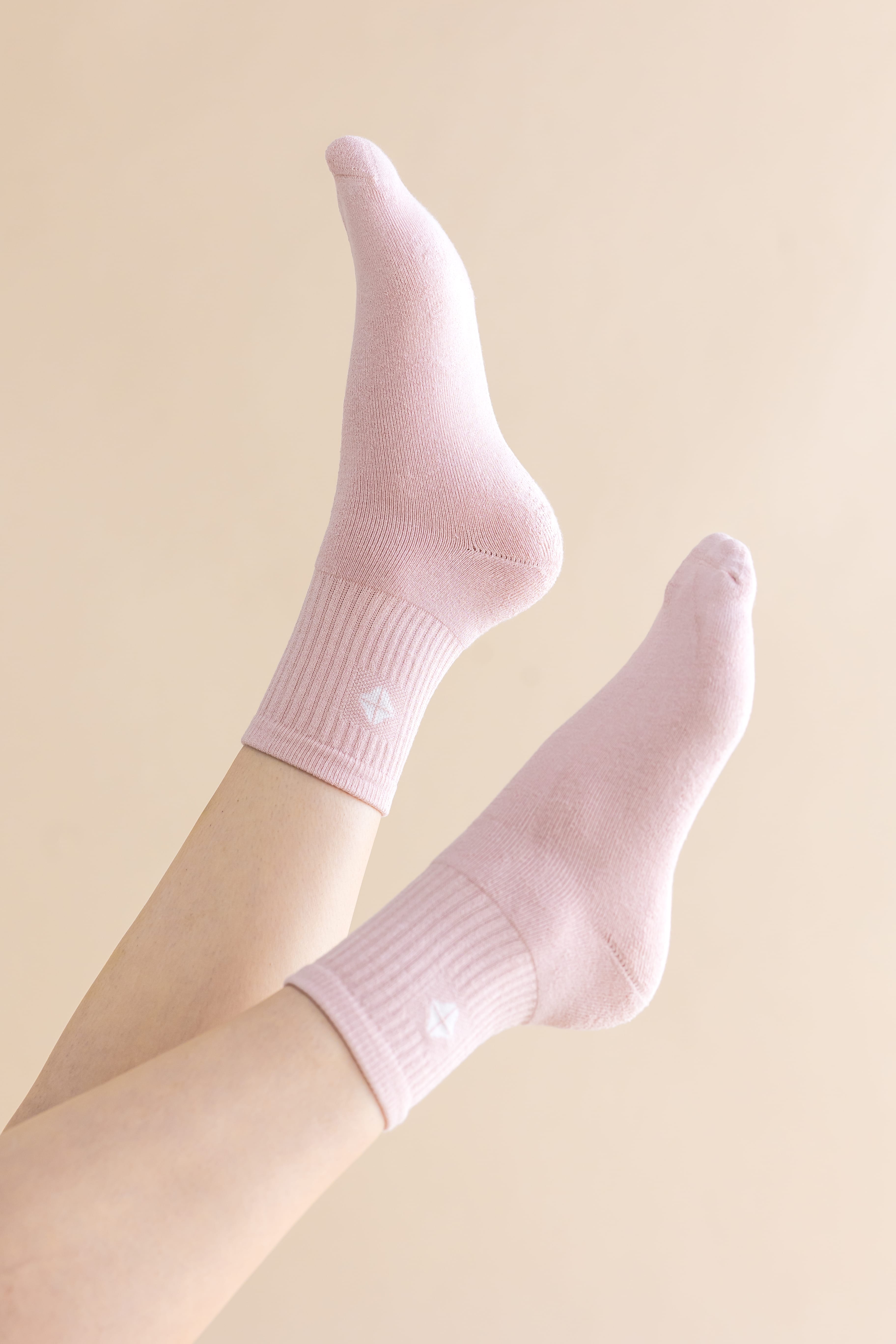 Adult Crew Socks in Blush shown on a models feet in the air against a cream colored wall