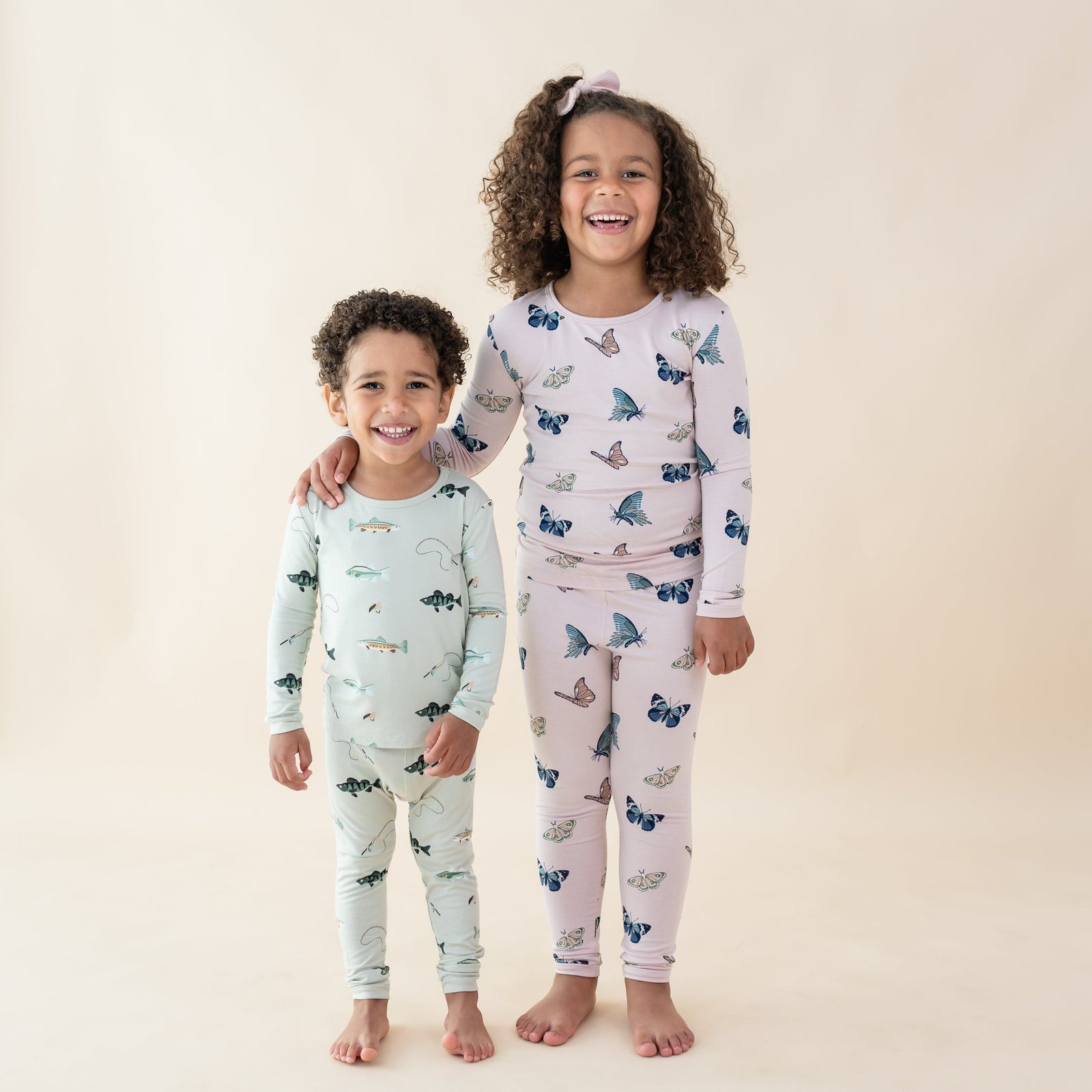 Two toddlers modeling Blush Butterfly and Fishing long sleeve pajamas