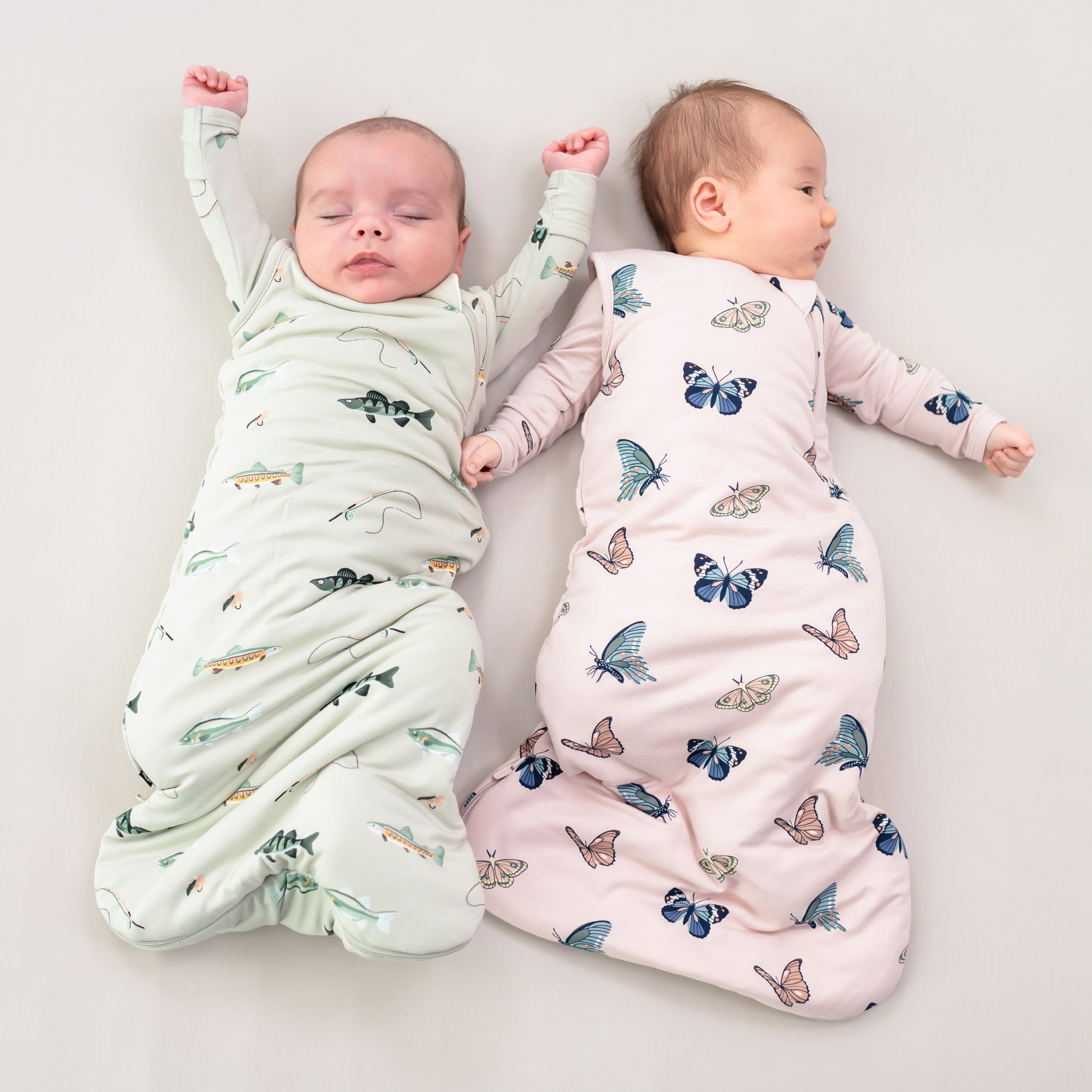 Two babies wearing sleep bags in fishing and blush butterfly 