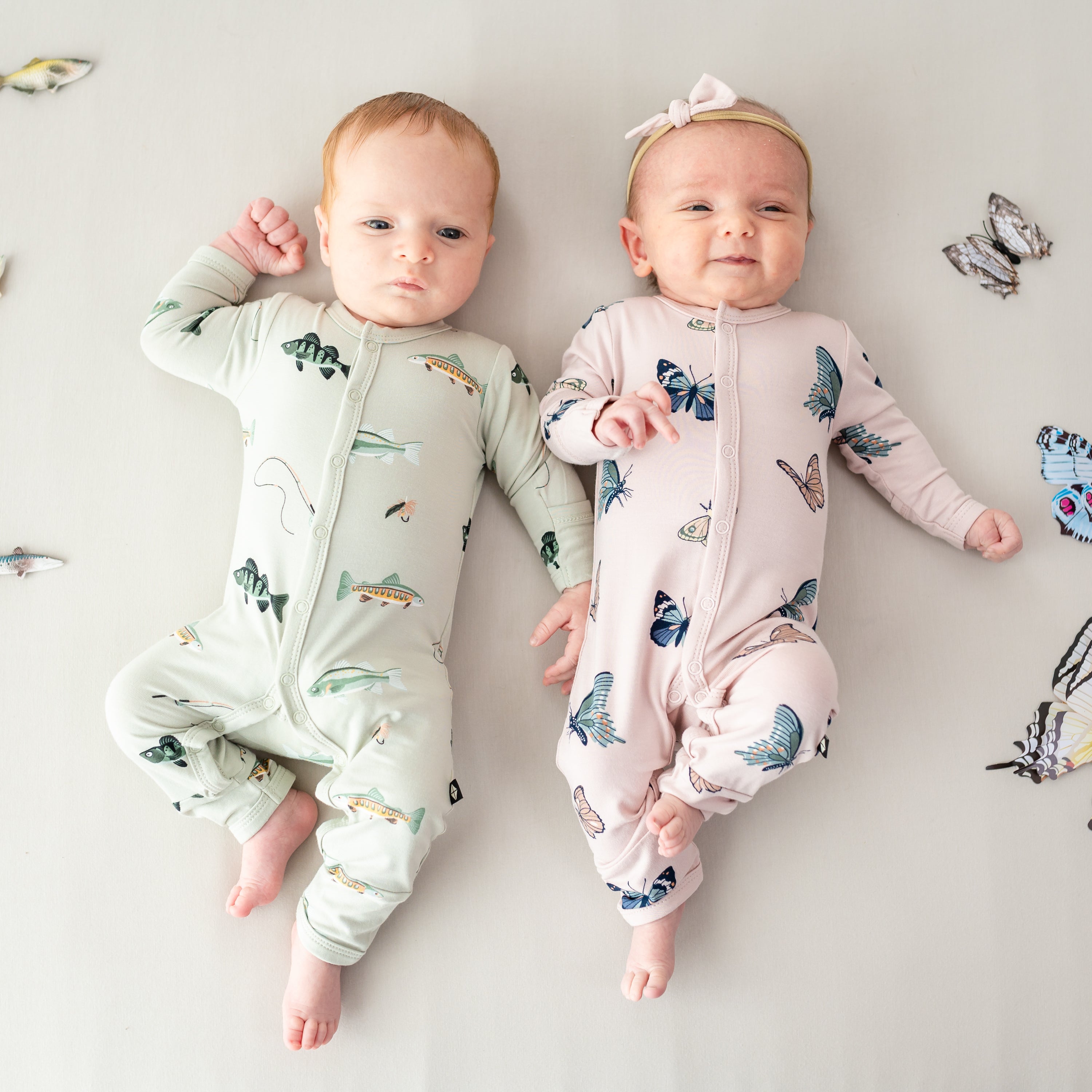 Two babies in Snap rompers in Fishing and Blush Butterfly