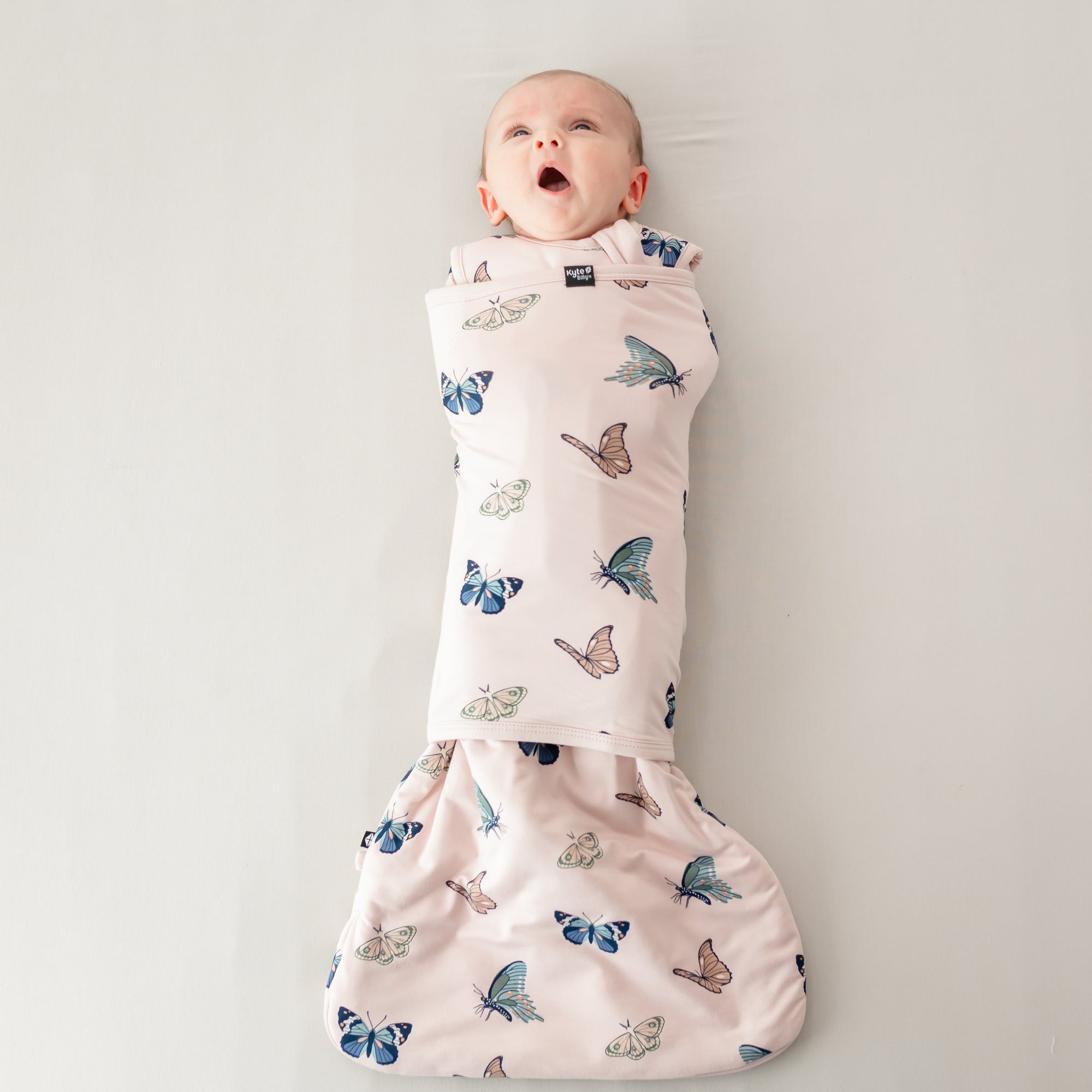 Baby yawning wearing Sleep bag swaddler in Blush Butterfly