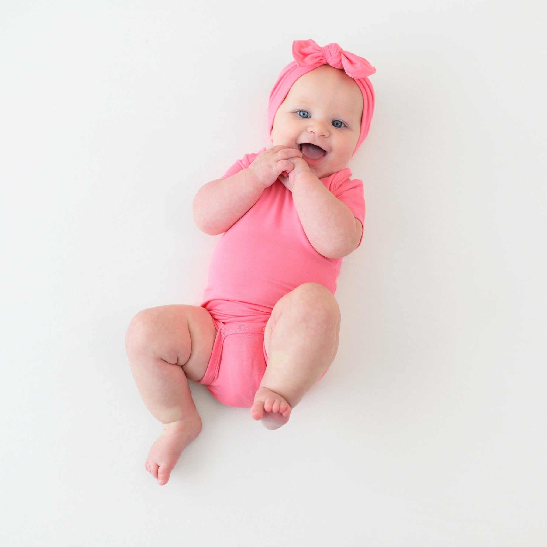 baby in bodysuit and bow in gauva