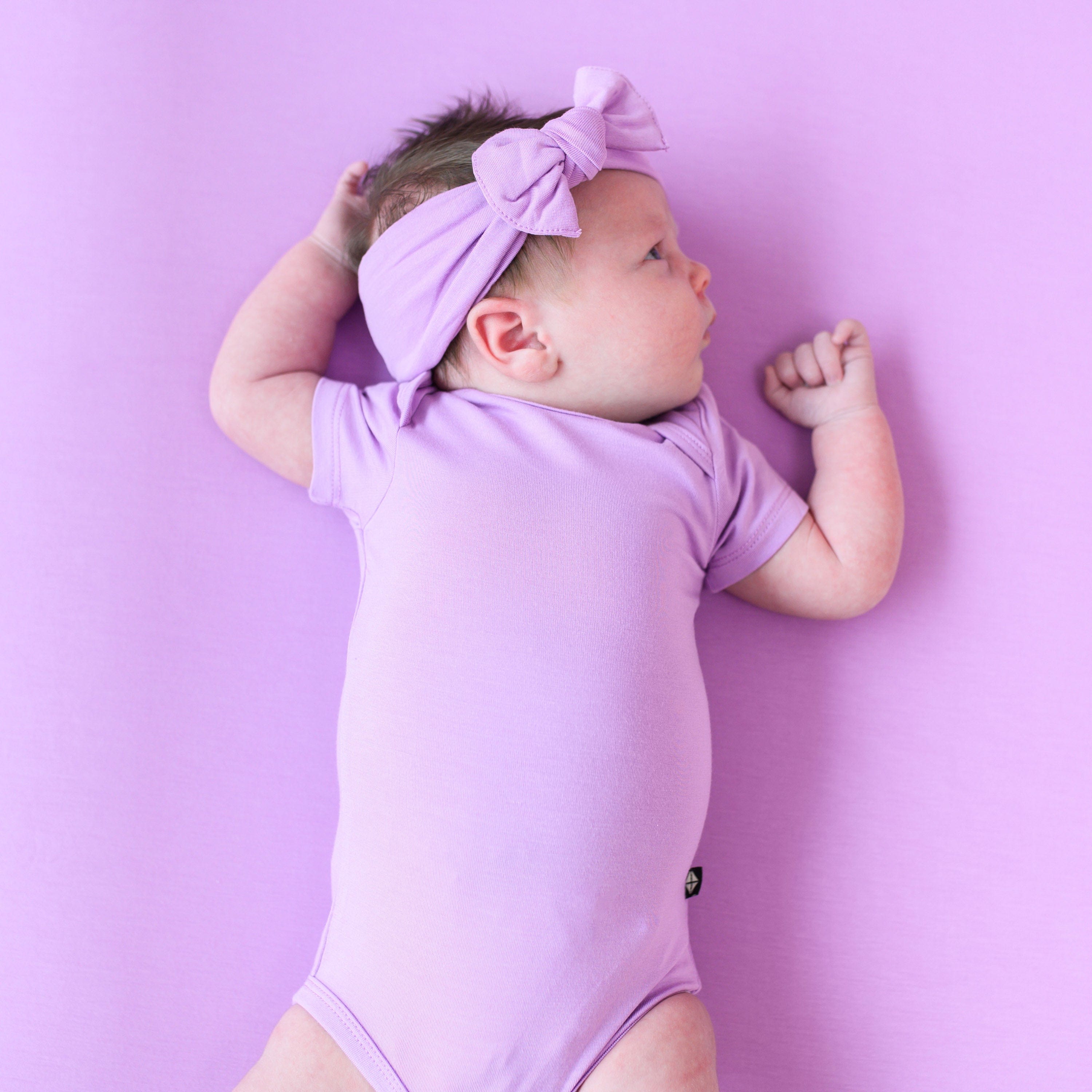 baby wearing poi short sleeve bodysuit and bow