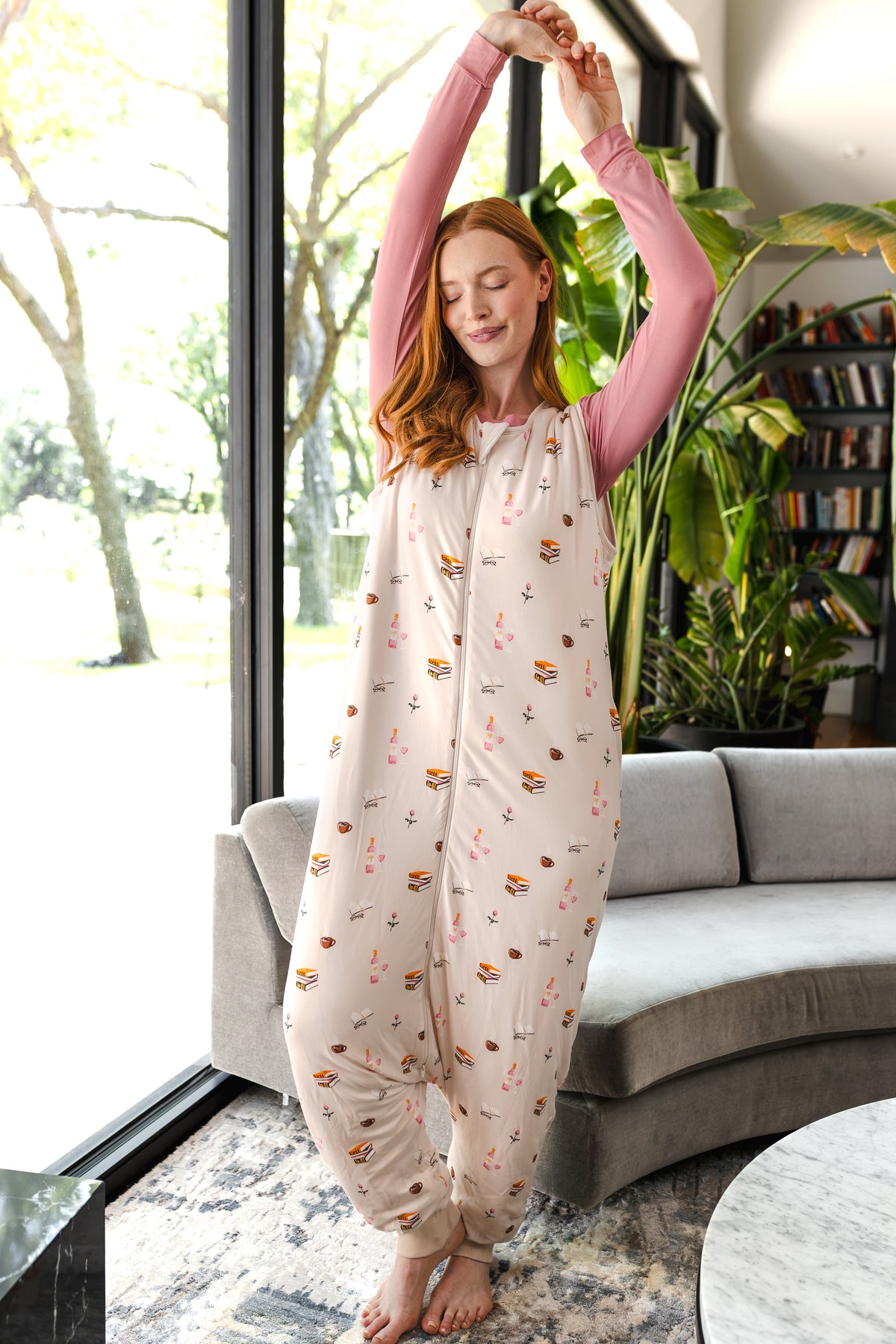 Modal posing in Adult Sleep Bag Walker in Book Club print standing in a living room