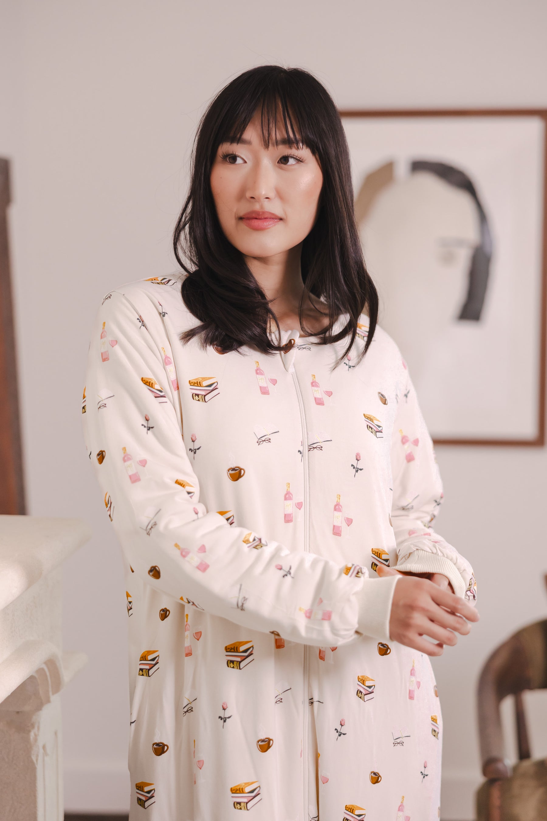 Modal posing in a room wearing Beige Long Sleeve Adult Sleep Bag Walker in Book Club print