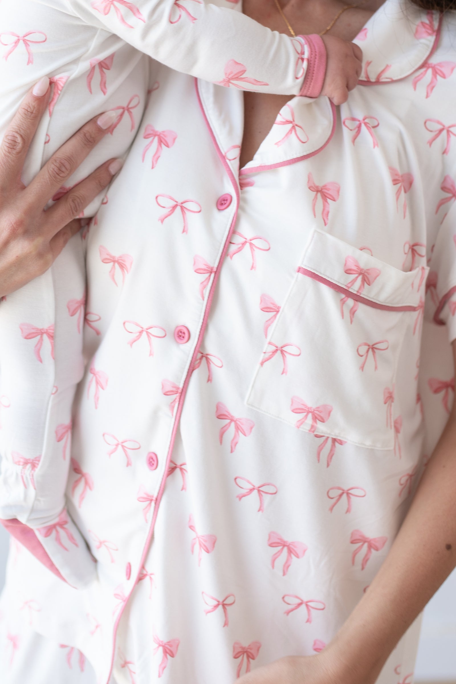 Close up of mom holding baby wearing matching bow print pajamas