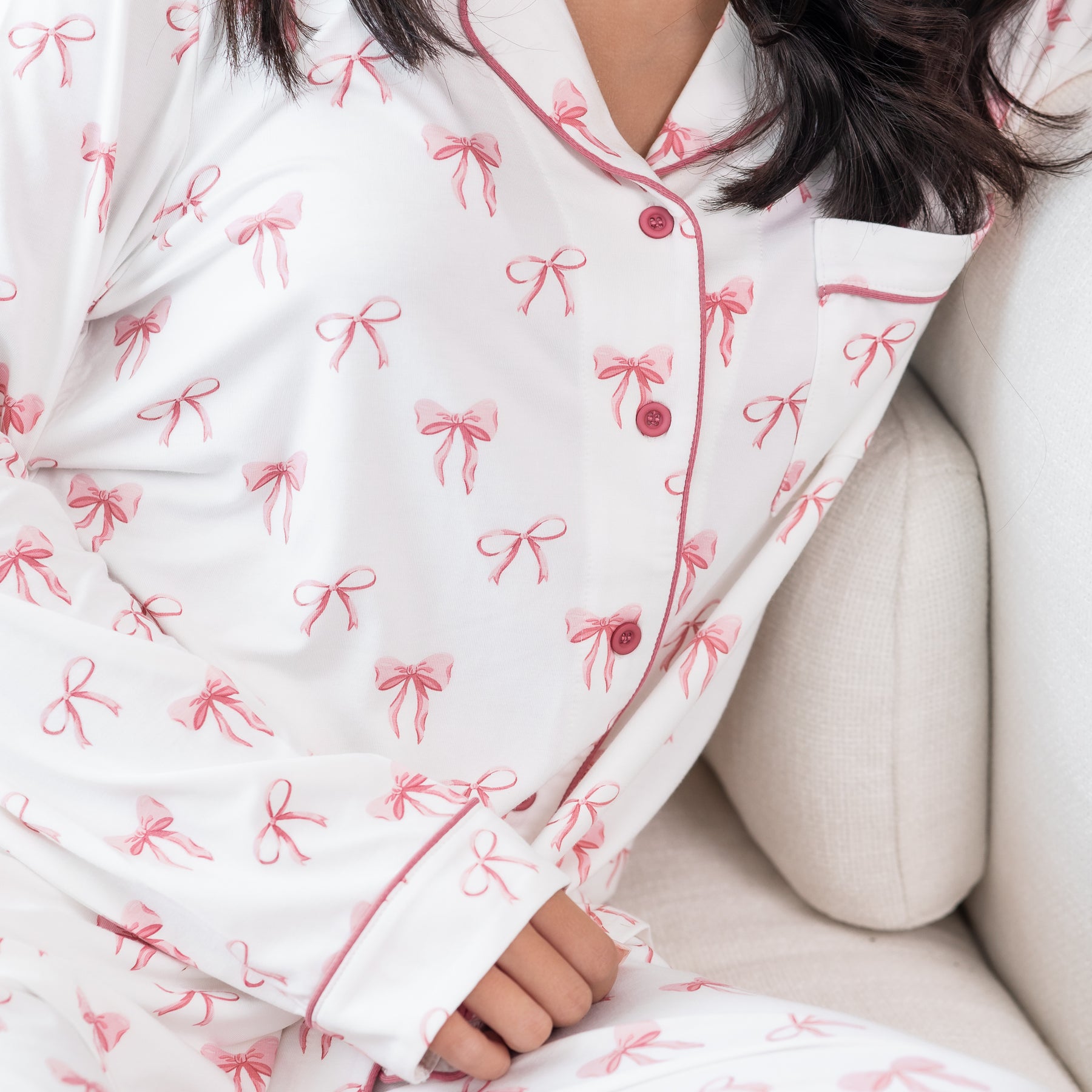 Close up of the button closure and Apple Blossom trim detail on the Long-Sleeved Women's Pajama Set in Bow shown on a model