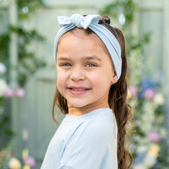 Young girl wearing the Knotted Bow Headband in Breeze