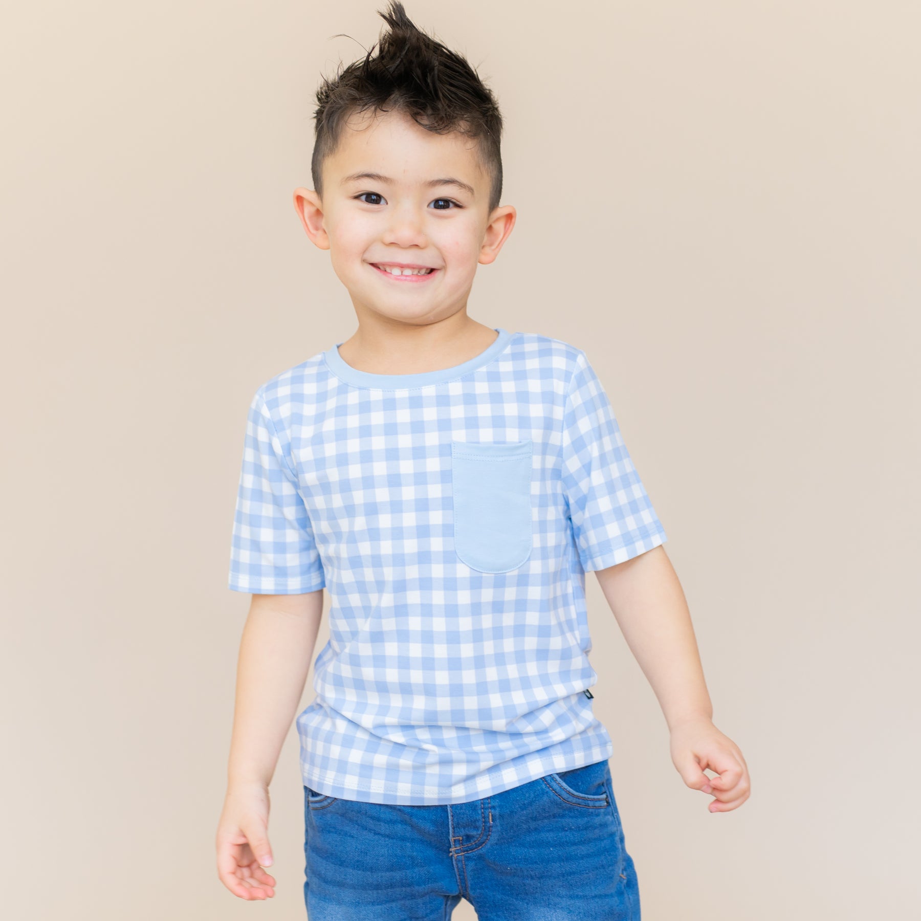 Young boy wearing the Toddler Crew Neck Tee in Gingham Breeze paired with medium wash jeans