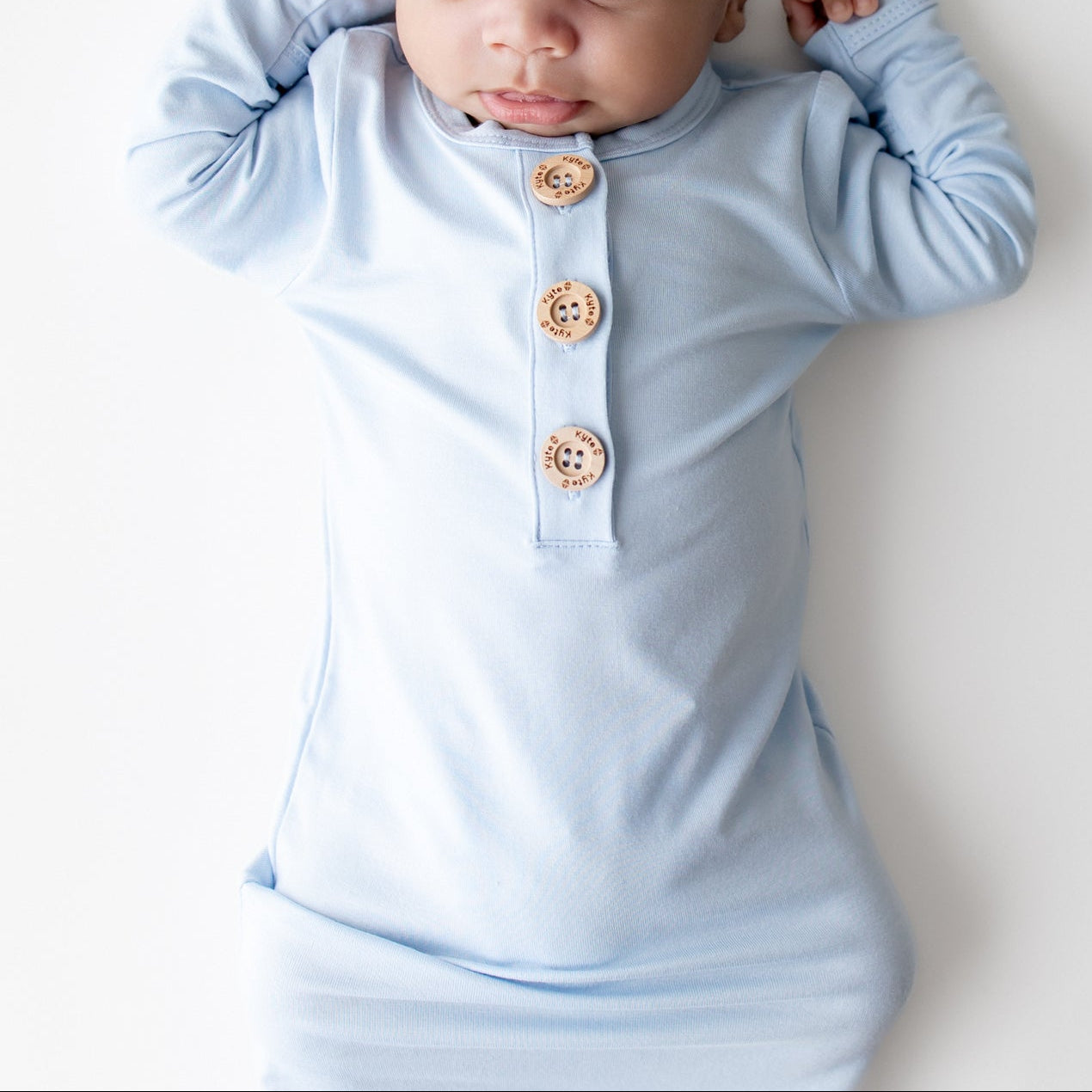 Close up of newborn wearing the Knotted Gown with Hat Set in Breeze