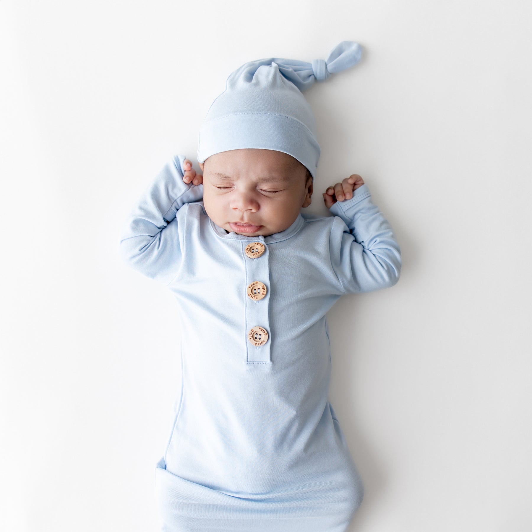 Close up of sleeping newborn wearing the Knotted Gown with Hat Set in Breeze