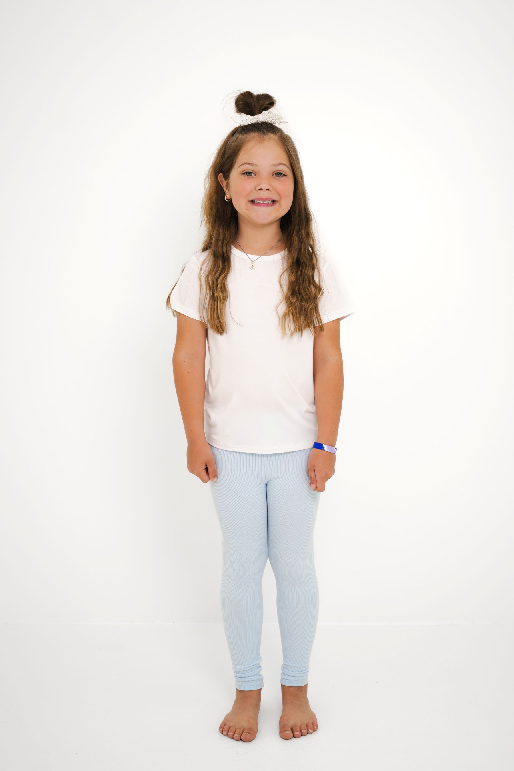 Young smiling girl modeling the Ribbed Leggings in Breeze with a white shirt