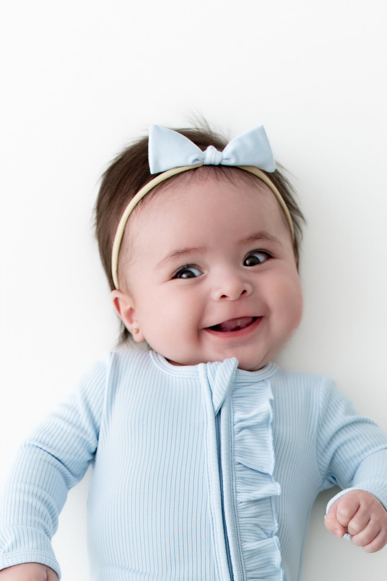 Close up of the zipper garage and ruffle trim shown on the Ribbed Ruffle Zipper Footie in Breeze