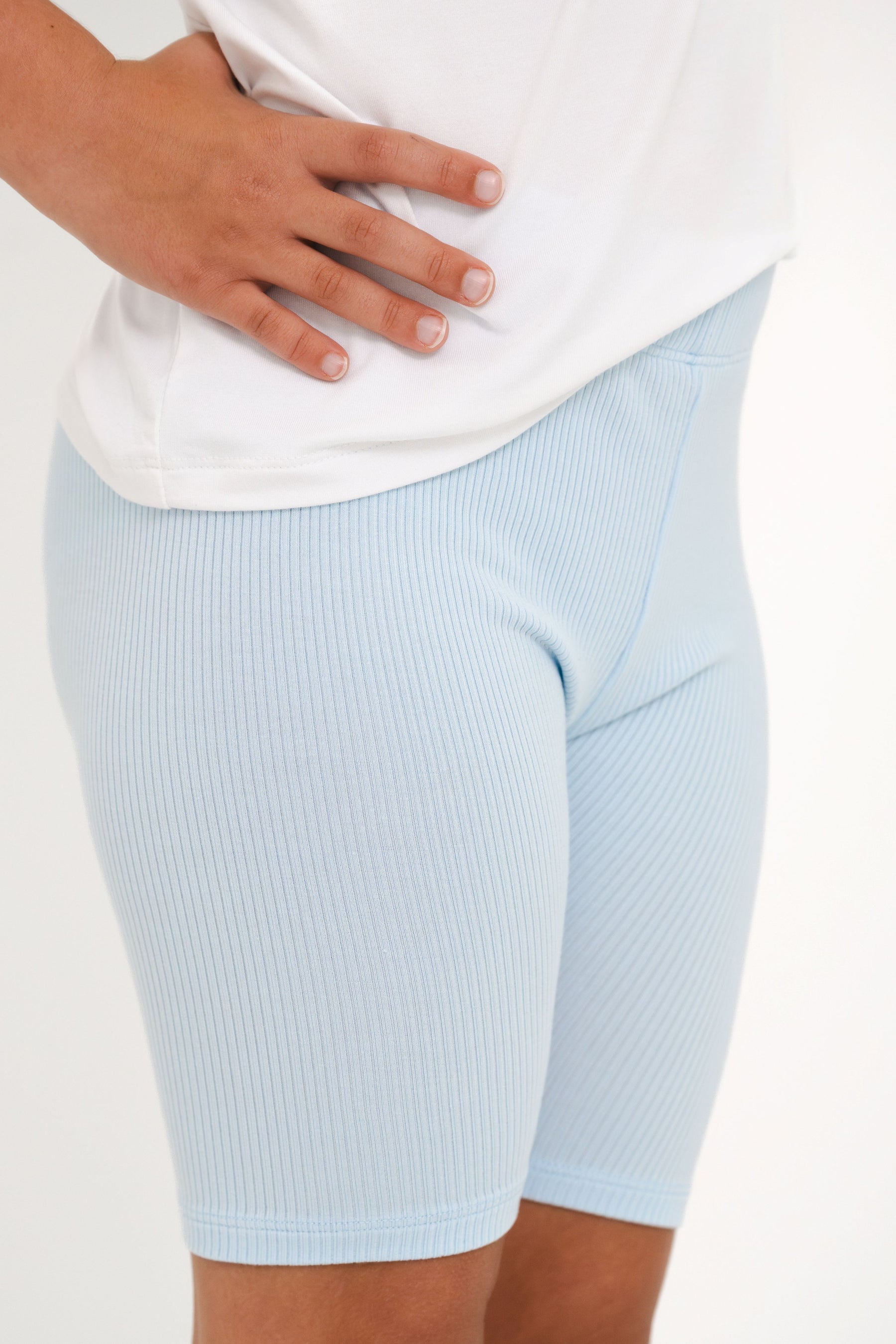 Close up of the ribbed fabric of the Ribbed Toddler Biker Shorts in Breeze shown on a young girl