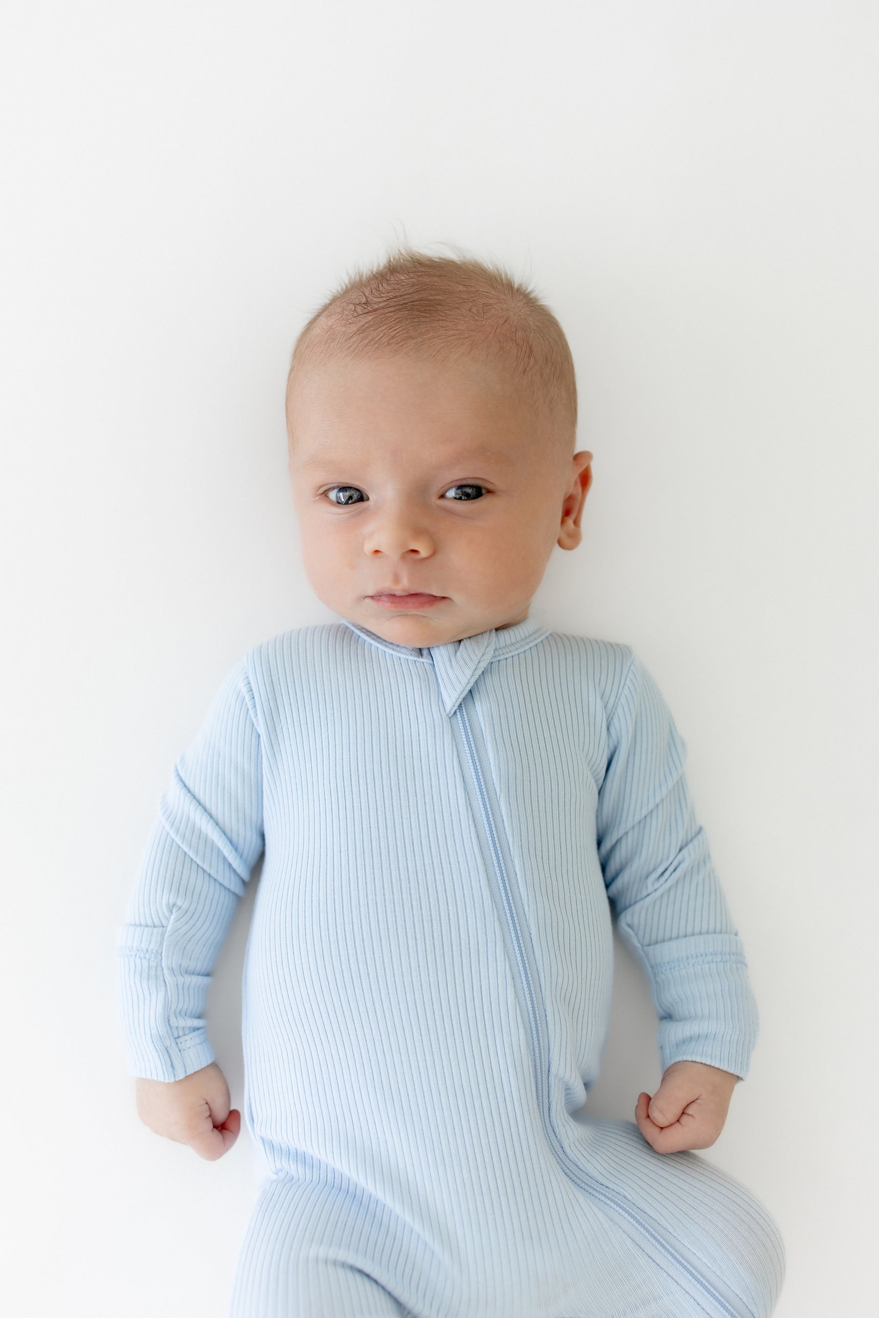 Close up of infant wearing the Ribbed Zipper Footie in Breeze
