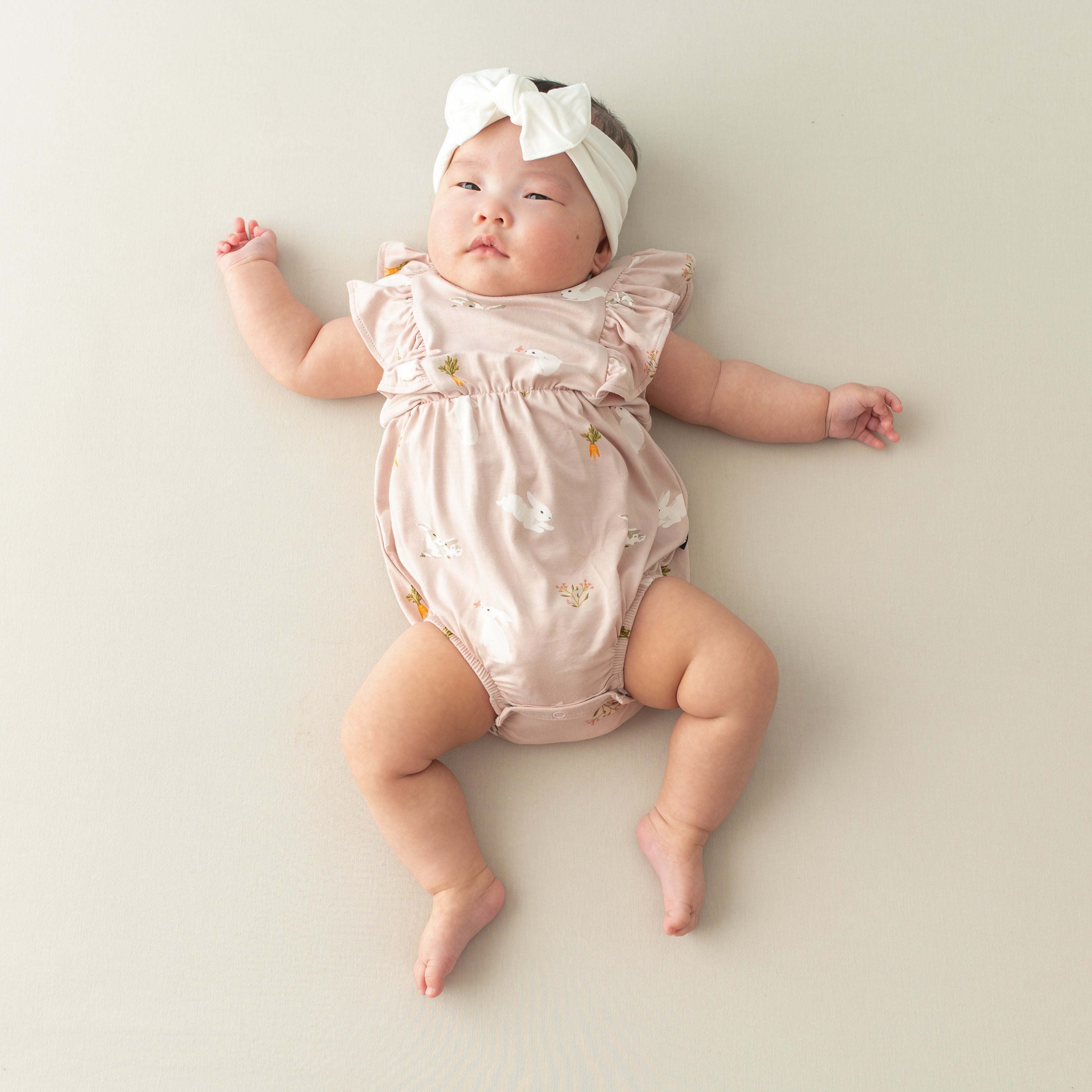 Baby in Bubble Romper in Blush Rabbit and cloud bow