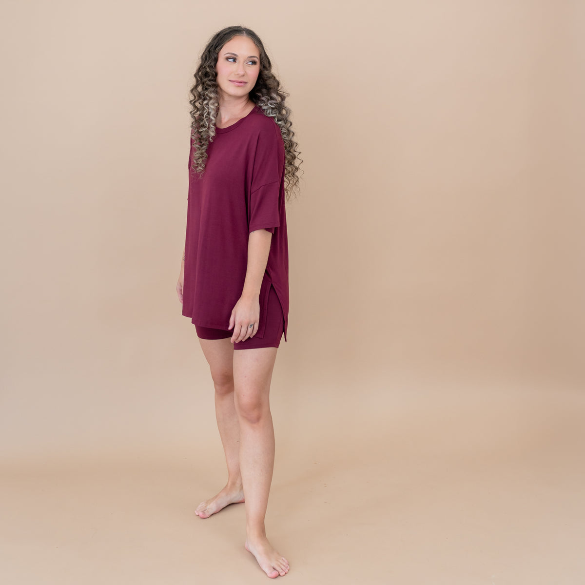 Female model standing looking off to the side wearing the Women’s Biker Short Set in Burgundy