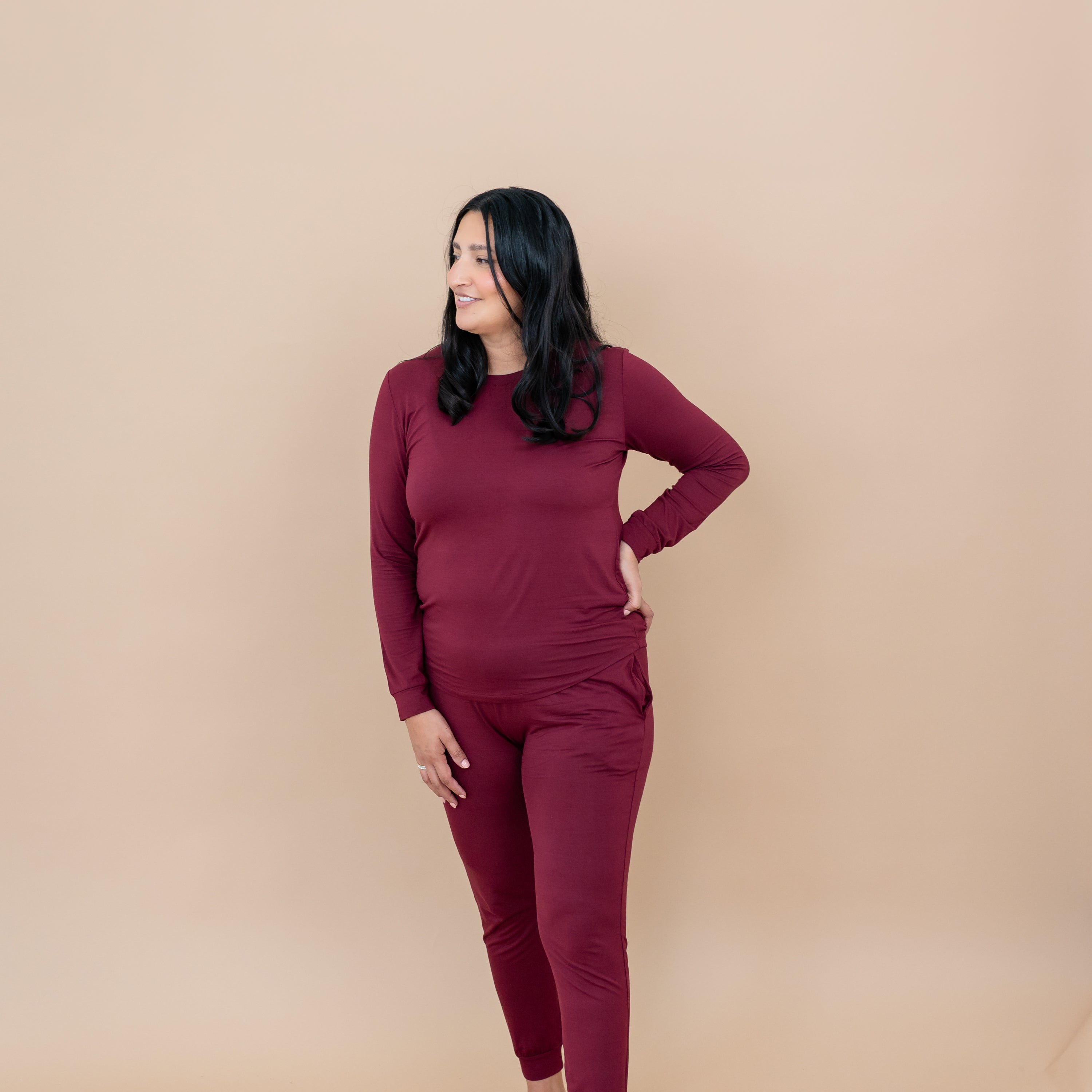 Female model standing looking off to one side wearing the Women's Jogger Pajama Set in Burgundy