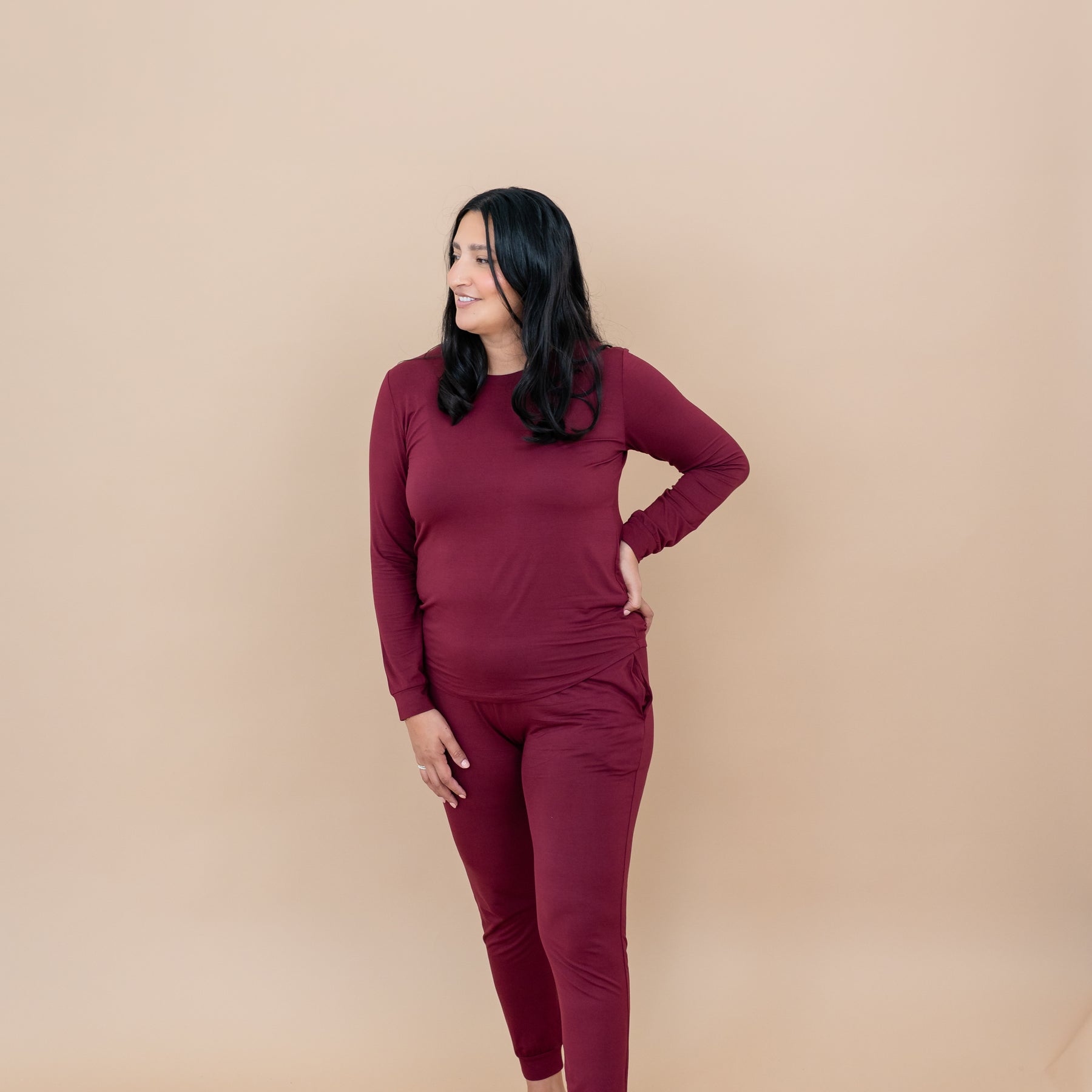 Female model standing looking off to one side wearing the Women's Jogger Pajama Set in Burgundy