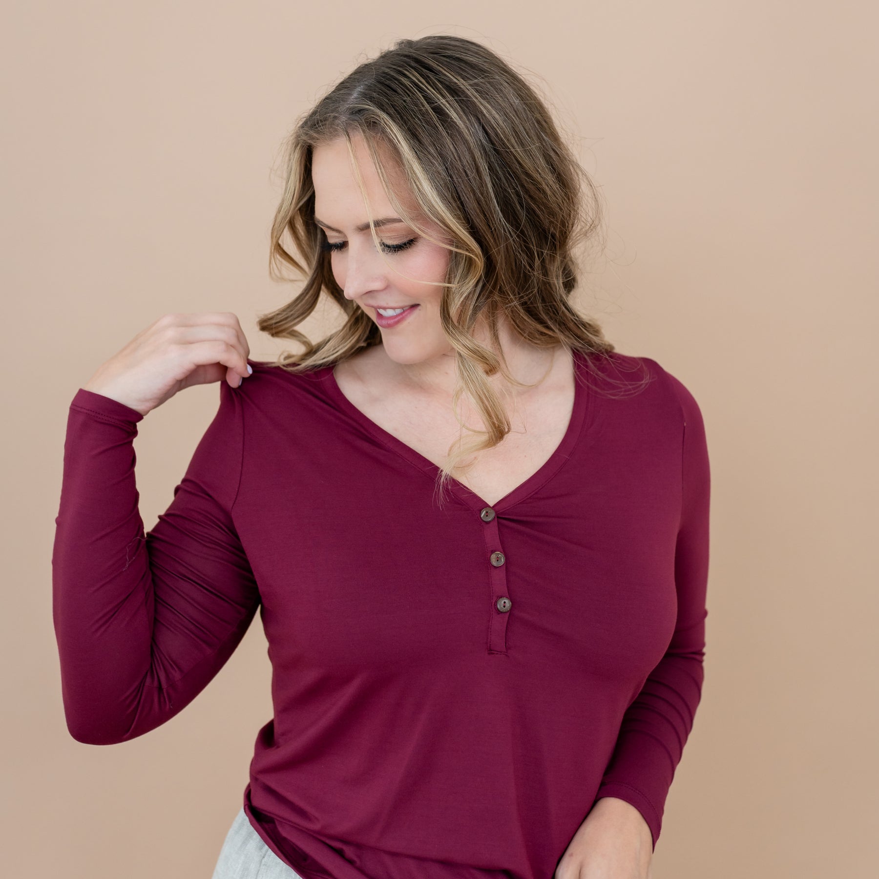 Close u of the Women's Long Sleeve Henley Tee in Burgundy on a female model