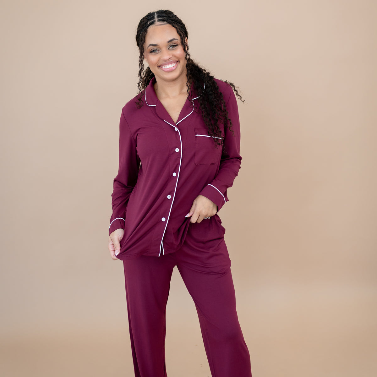 Smiling female model wearing the Long-Sleeved Women's Pajama Set in Burgundy with Cloud Trim