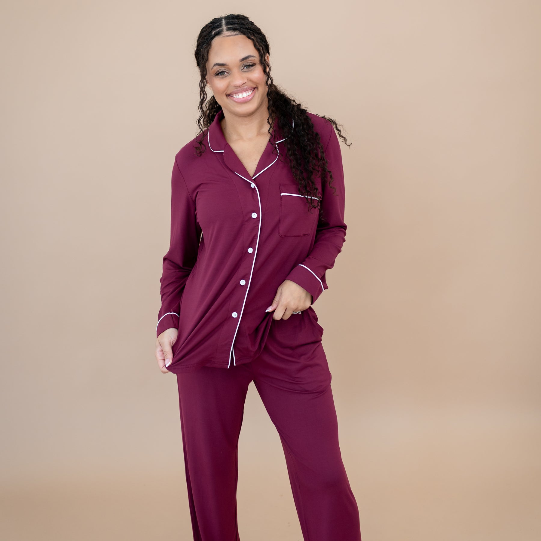 Smiling female model wearing the Long-Sleeved Women's Pajama Set in Burgundy with Cloud Trim
