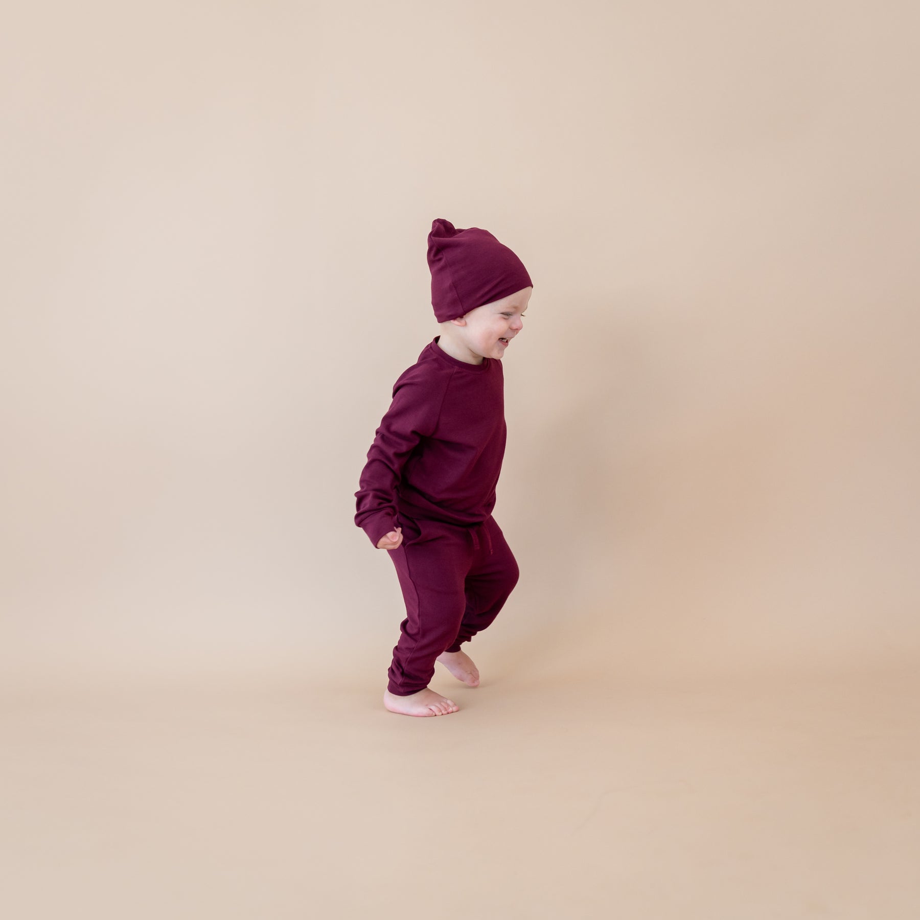 Toddler wearing Bamboo Jersey Beanie in Burgundy and matching jogger pajamas