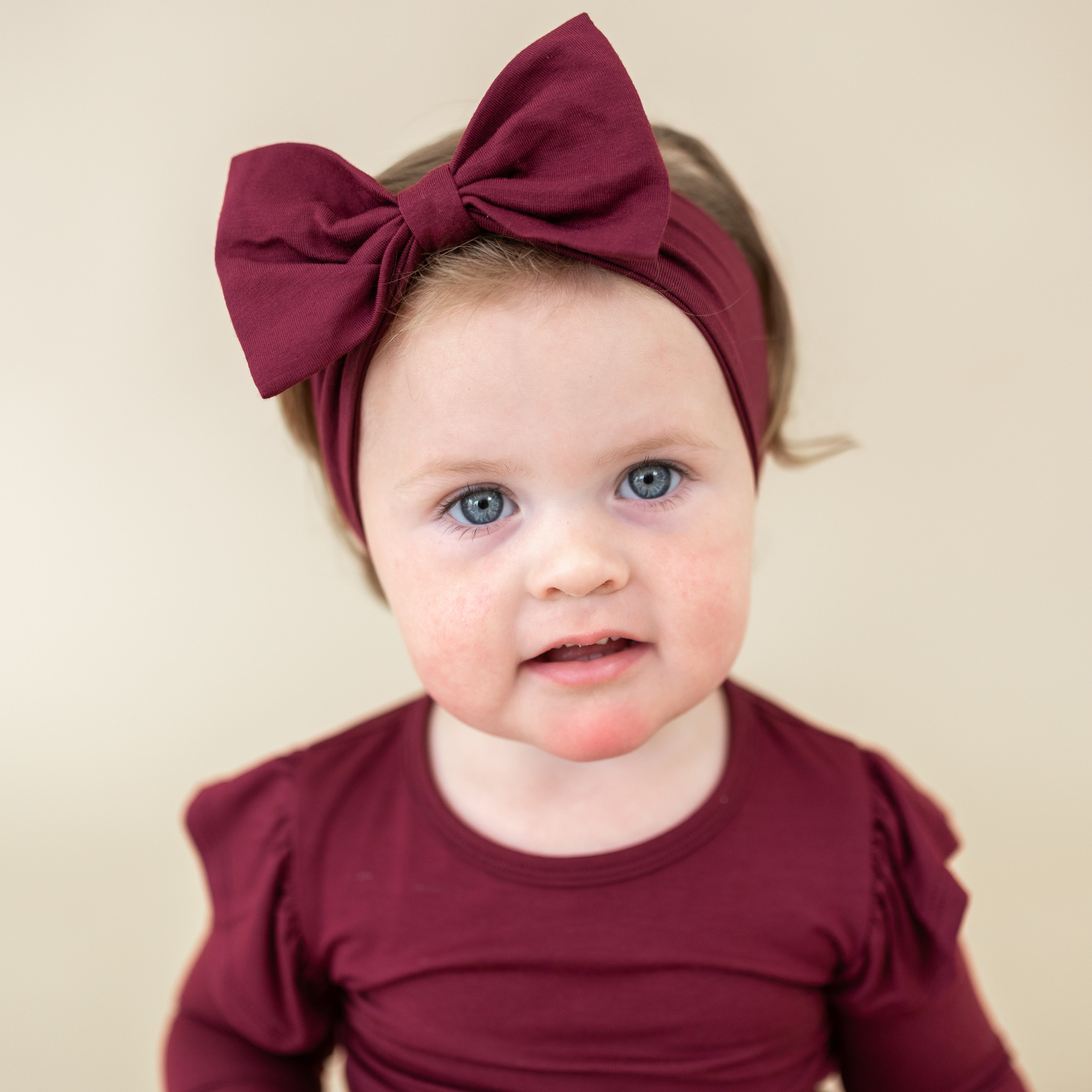 Toddler wearing the Bow Headband in Burgundy with the matching long sleeve twirl bodysuit dress