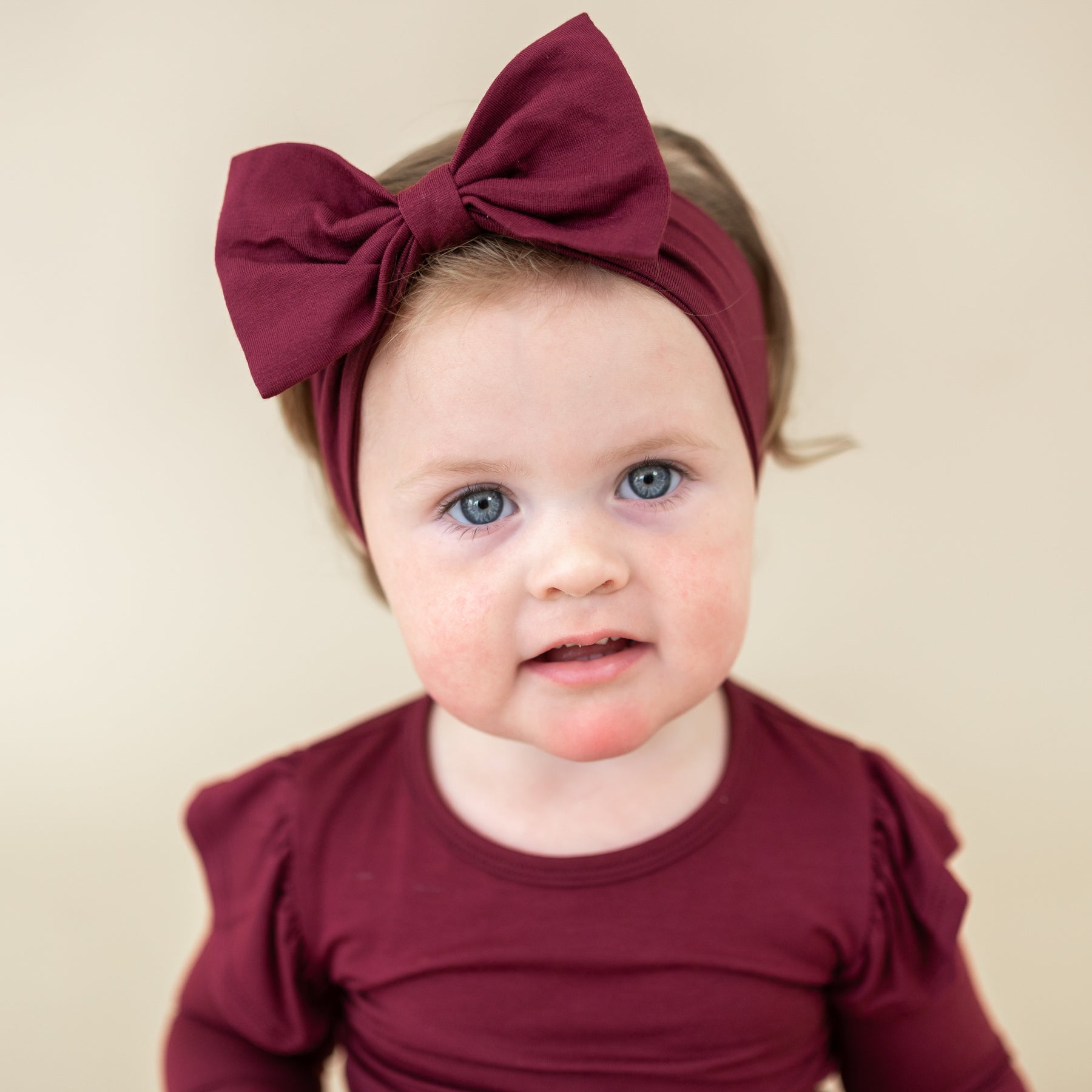 Toddler wearing the Bow Headband in Burgundy with the matching long sleeve twirl bodysuit dress