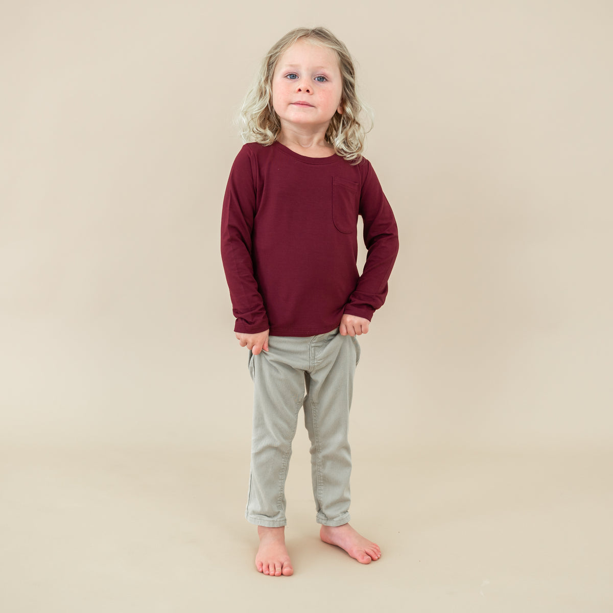 Toddler wearing the Long Sleeve Toddler Crew Neck Tee in Burgundy with light wash jeans