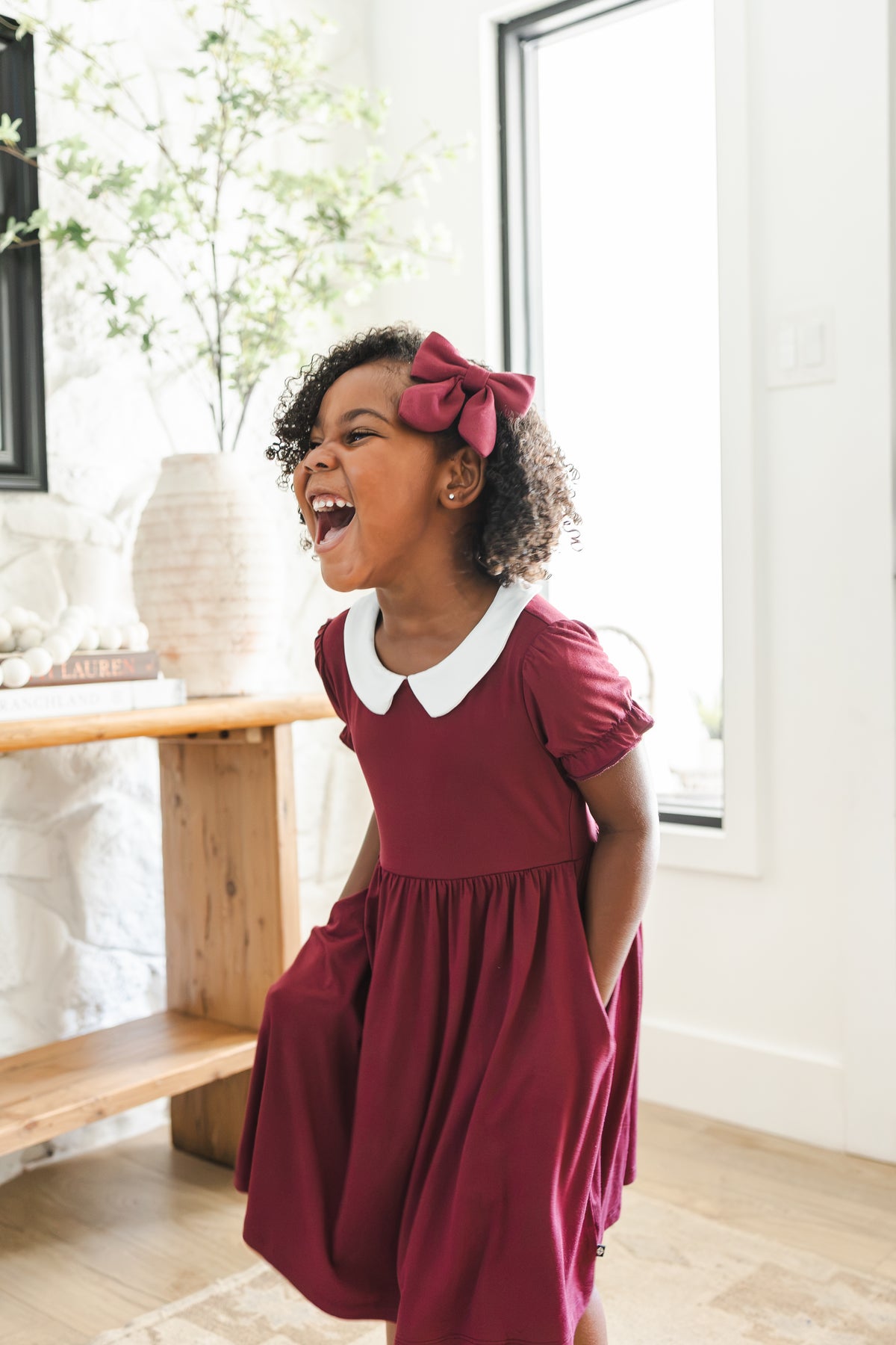 Girl laughing in Peter Pan Collar Dress in Burgundy with Medium Alligator clip bow 