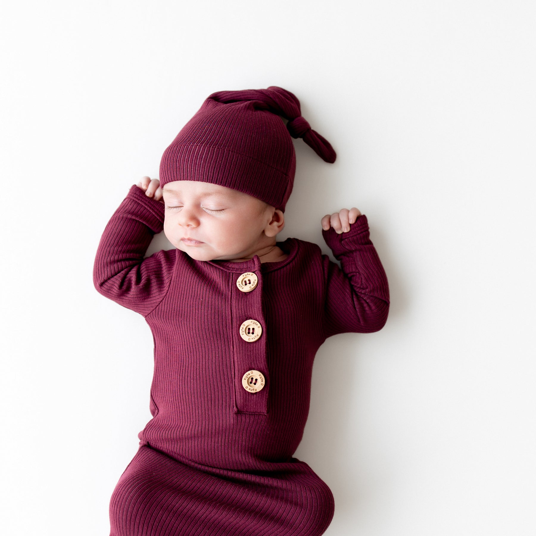 Close up of sleeping infant wearing the Ribbed Knotted Gown with Hat Set in Burgundy
