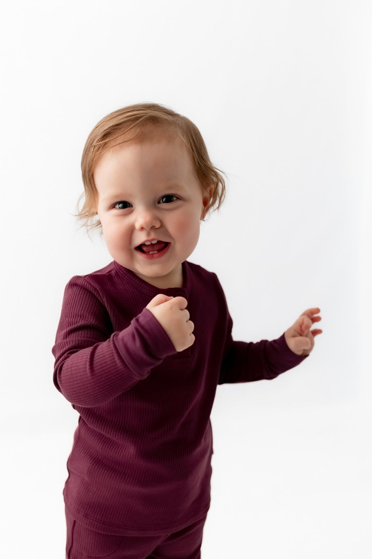 Toddler smiling in Ribbed Infant Henley Set in Burgundy on a white background