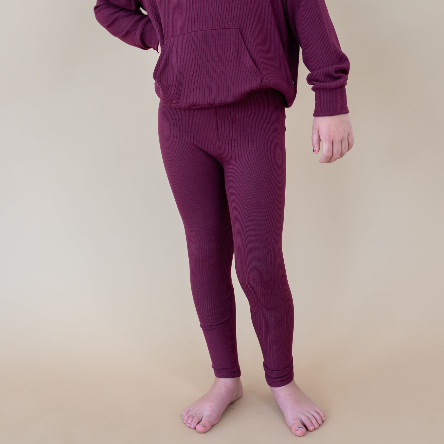 Close up of the Ribbed Leggings in Burgundy shown on a model