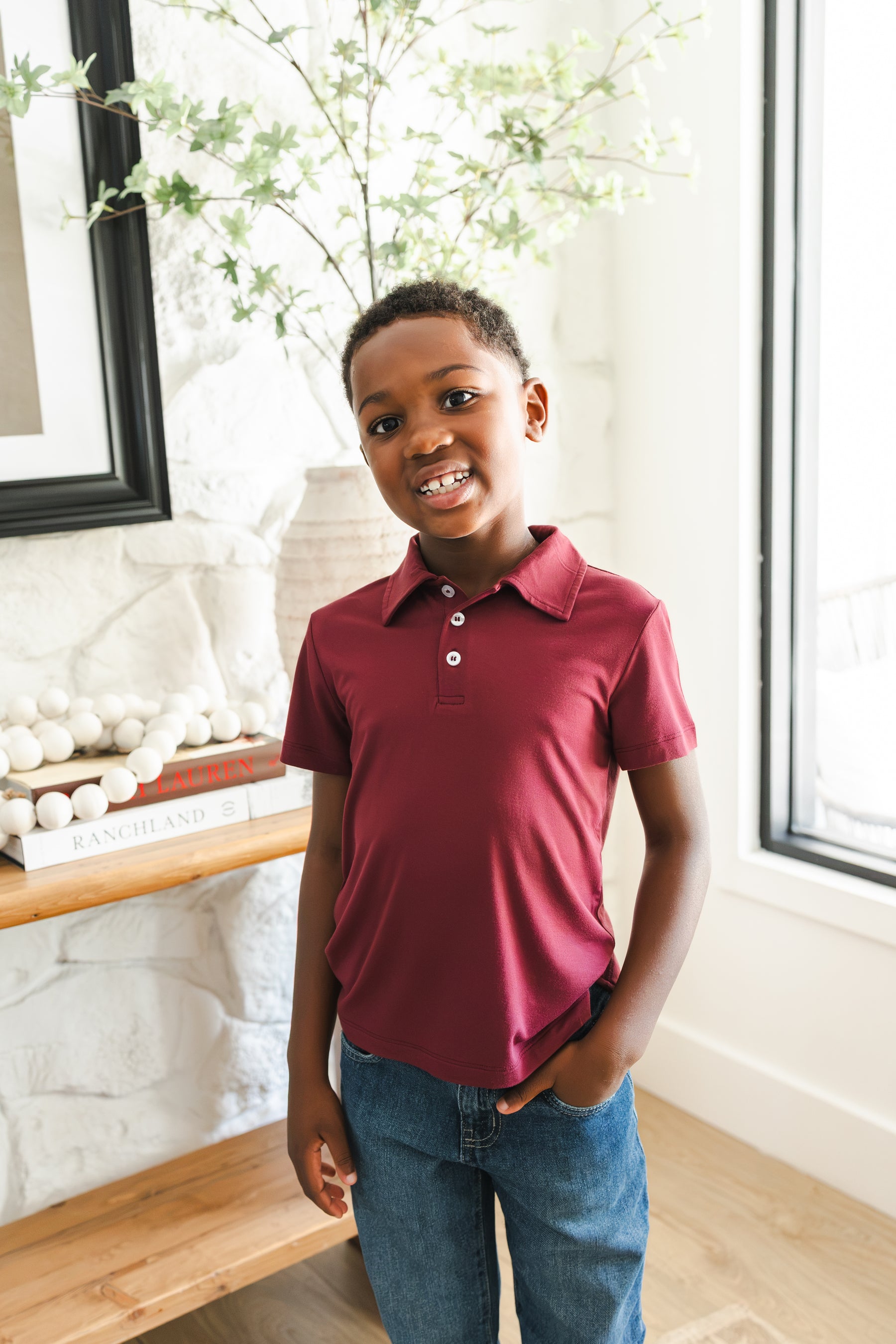 Boy wearing Toddler Short Sleeve Polo in Burgundy on blue jeans