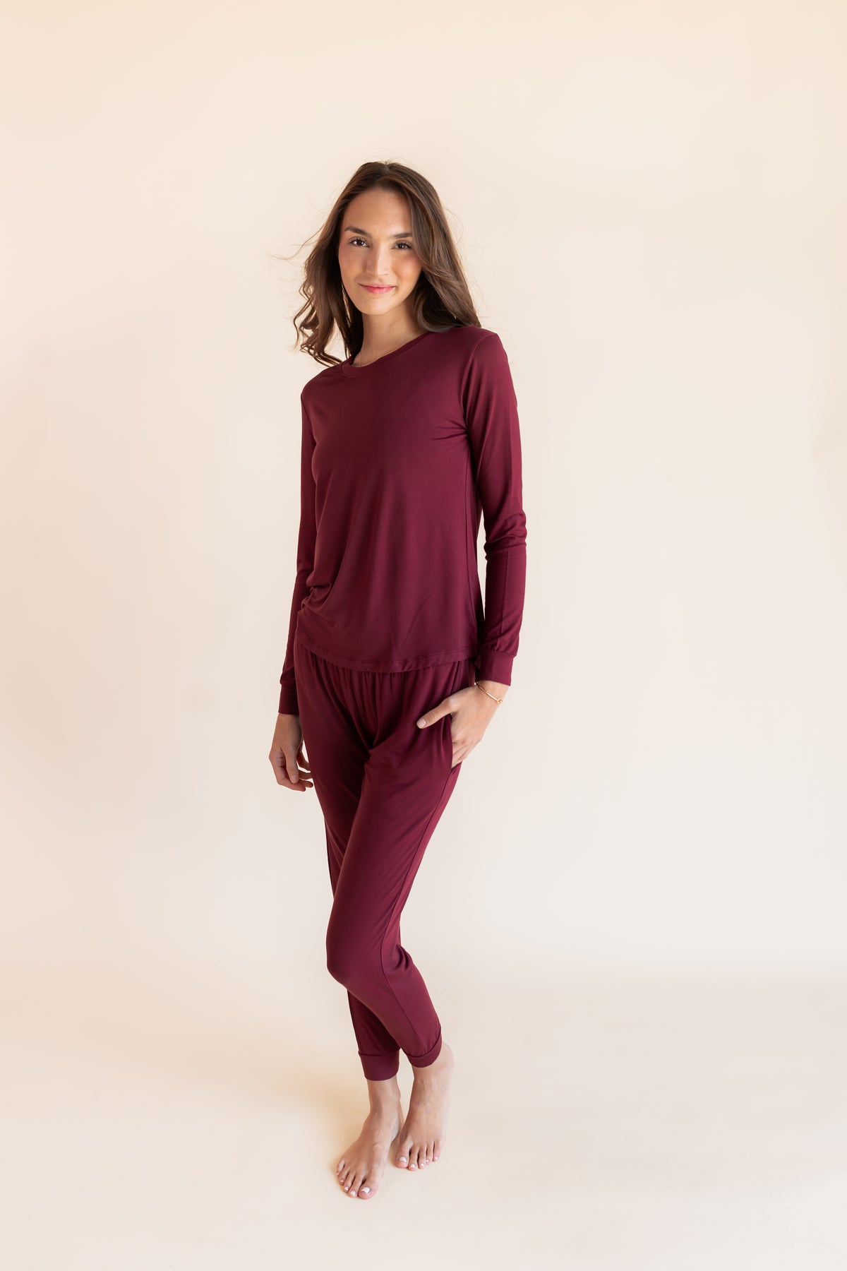 Model wearing Women's Jogger Pajama Set in Burgundy on a beige background