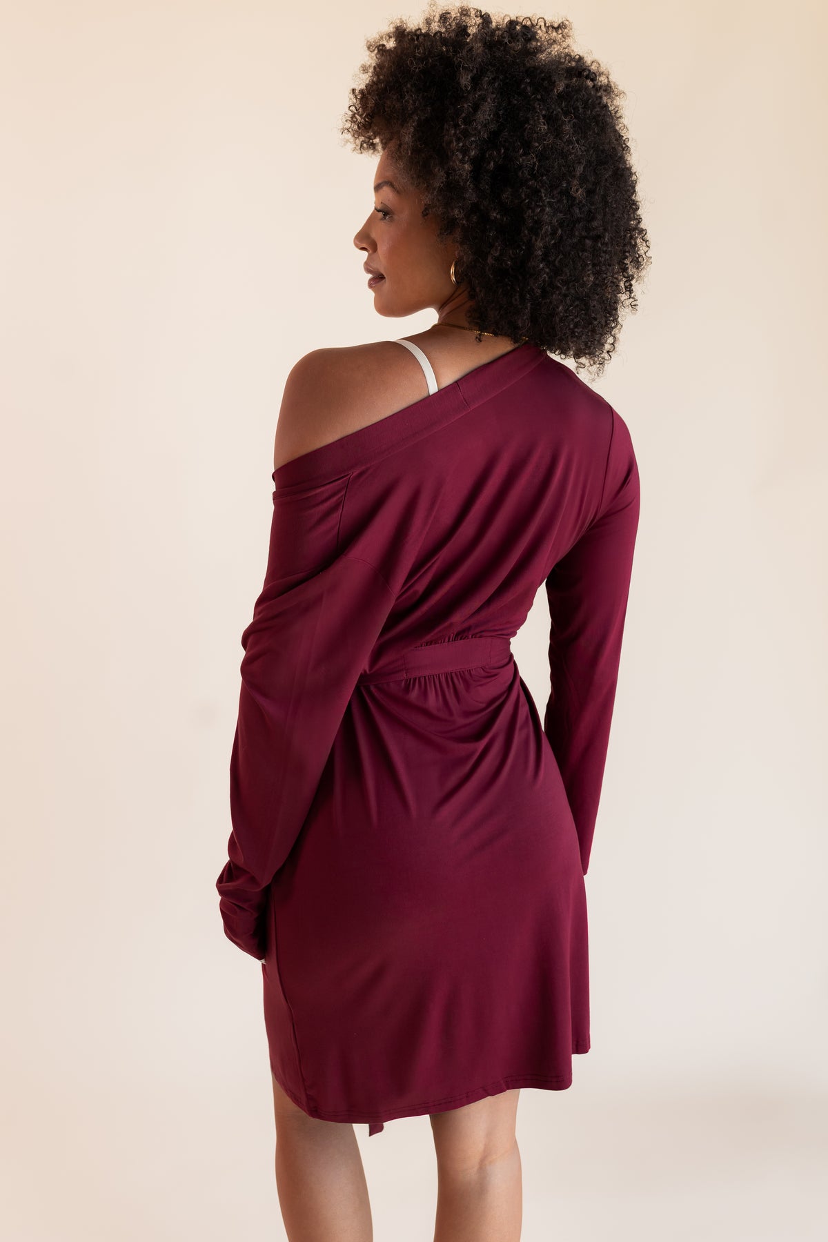 Model showcasing back side of Women's Lounge Robe in Burgundy on a beige background