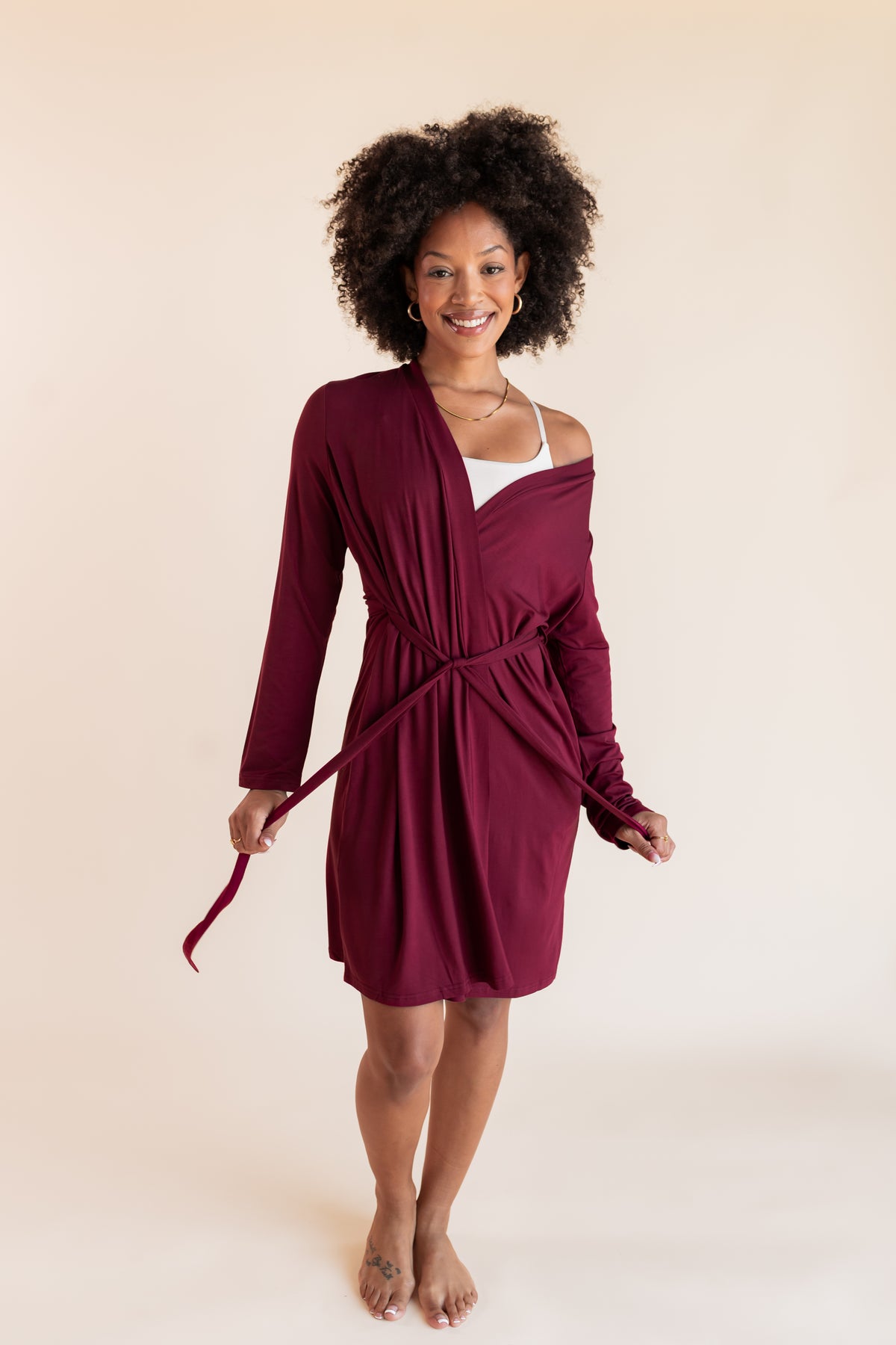 Model wearing Women's Lounge Robe in Burgundy with belt on a beige background