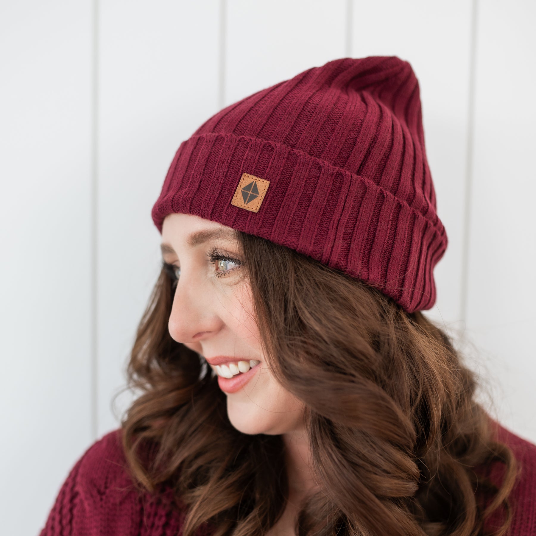 Close up of the Chunky Knit Adult Ribbed Beanie in Burgundy shown on a female model