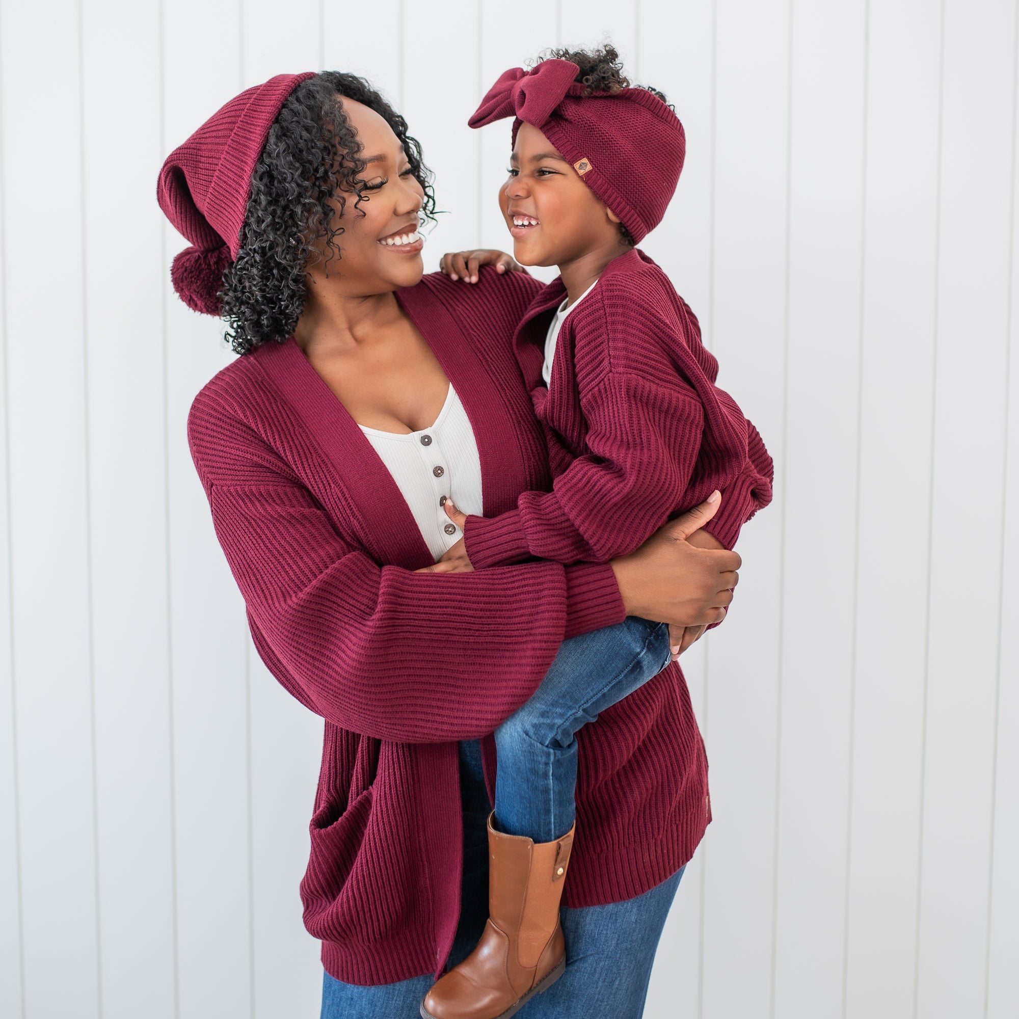 Mother holding daughter matching in Burgundy Chunky Knit items