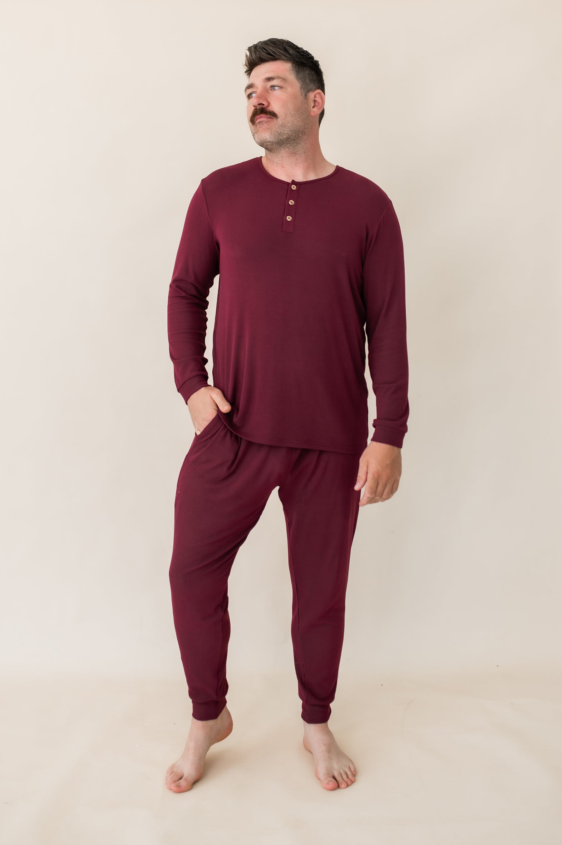 Male modeling the Men's Ribbed Henley Set in Burgundy with one hand in the pants pocket