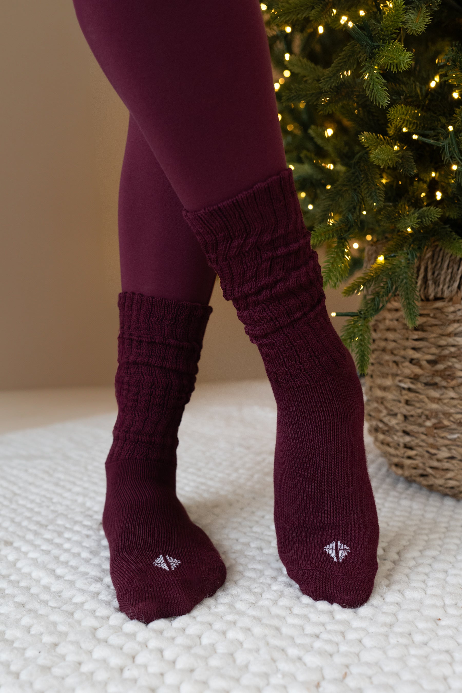 Burgundy textured socks worn with leggings against a neutral background
