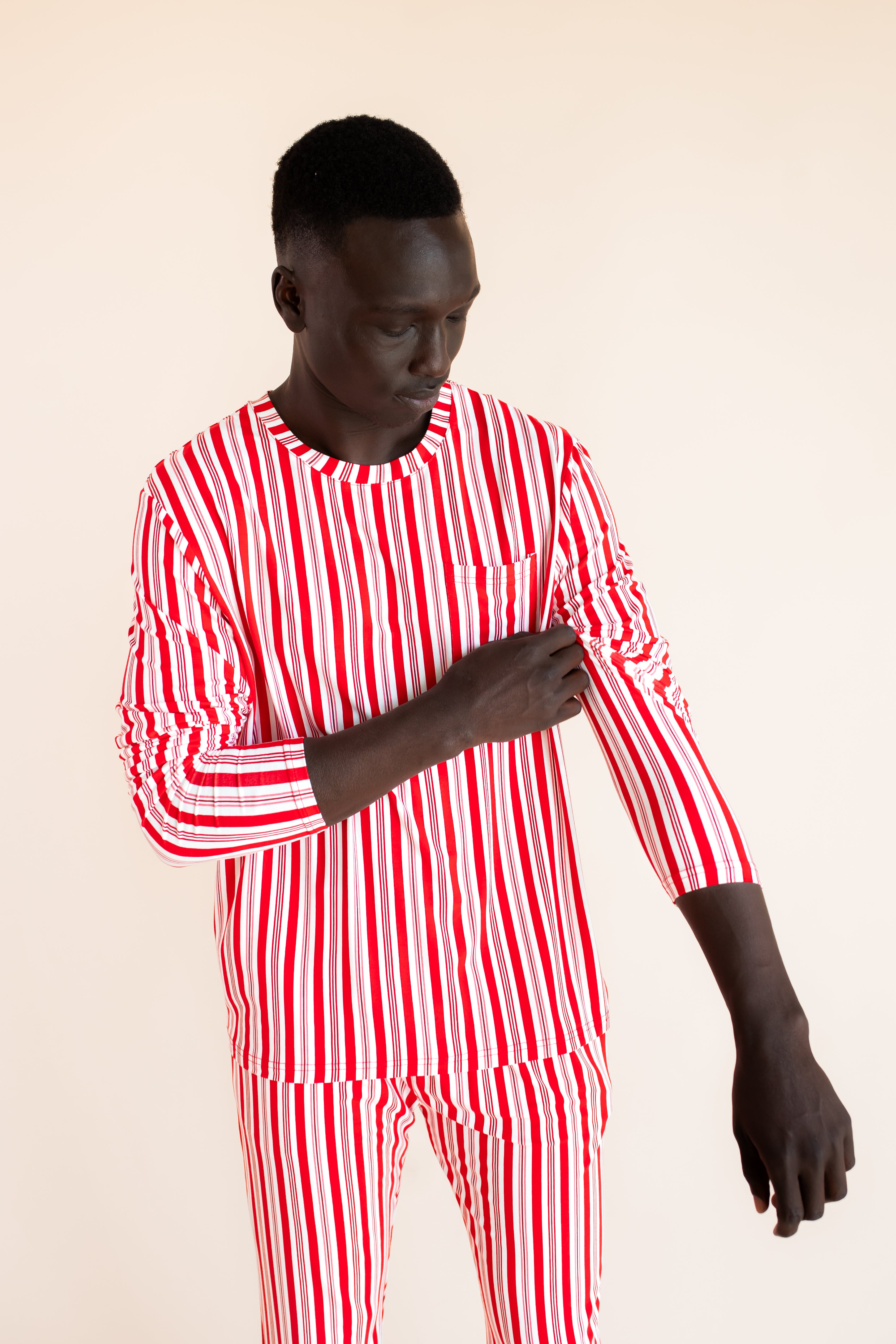 Modal wearing Men's Jogger Set in red and white Peppermint Stripes print on a  beige background
