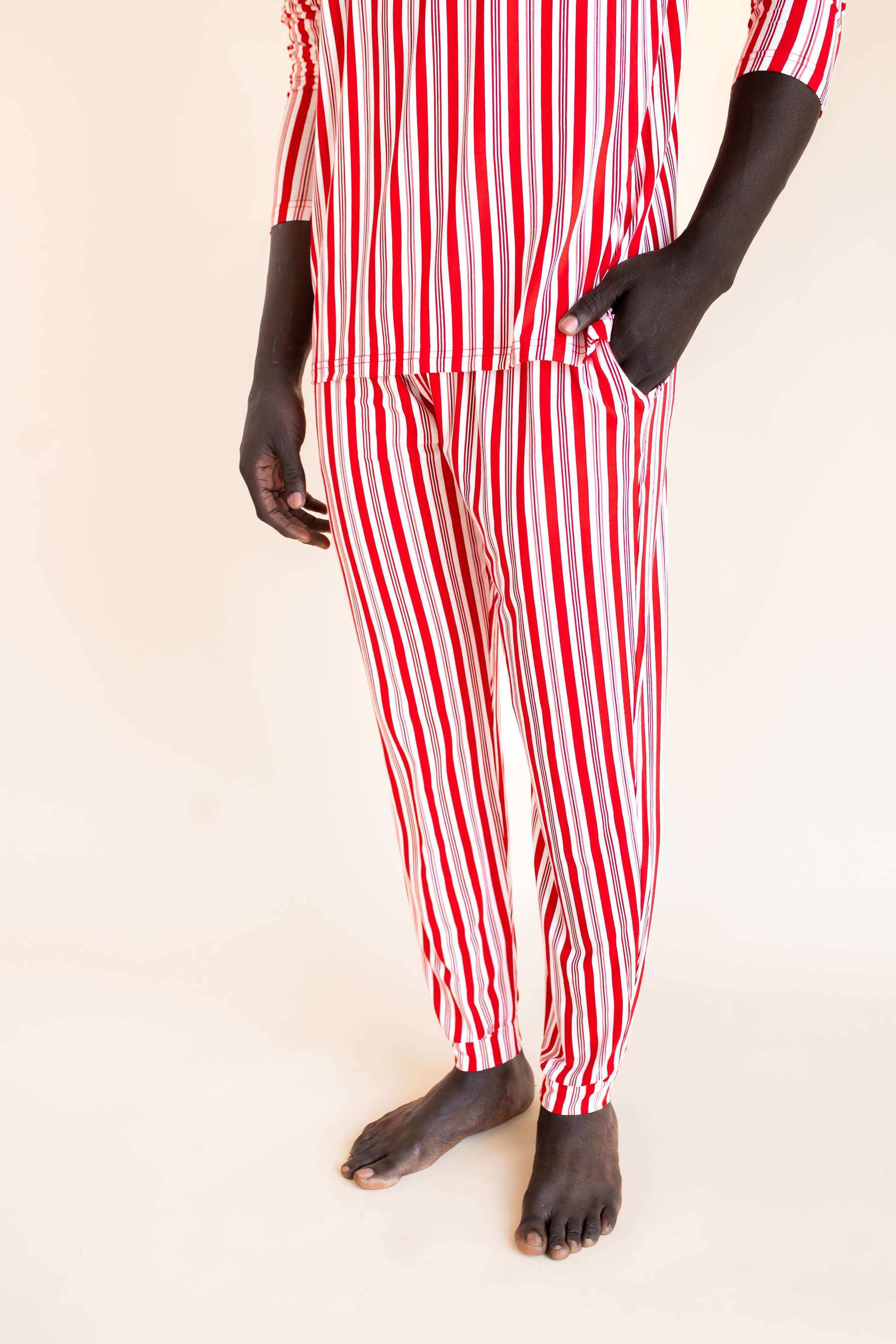 Modal showcasing the pants with pockets on Men's Jogger Set in red and white Peppermint Stripes print on a  beige background