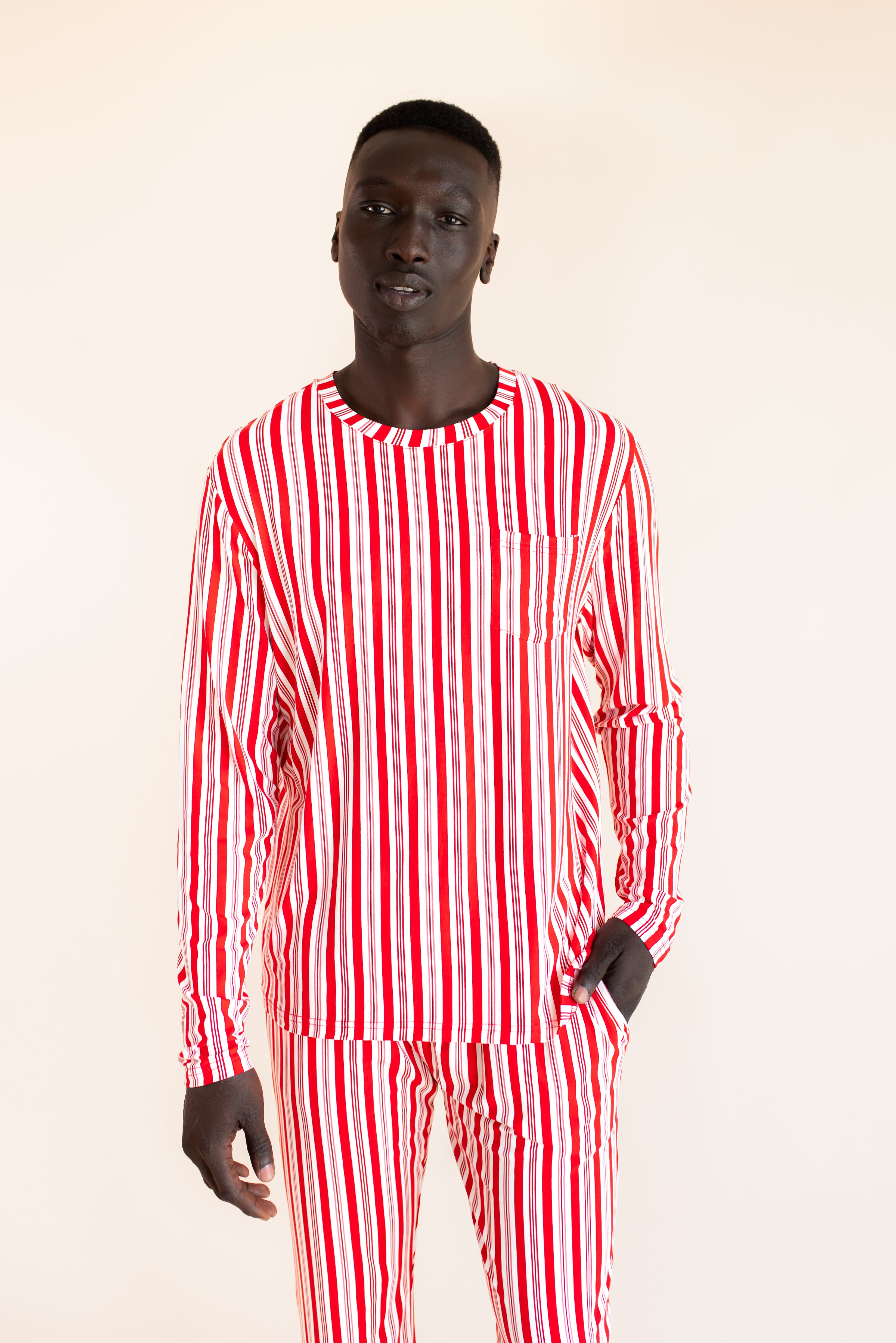 Modal wearing Men's Jogger Set in red and white Peppermint Stripes print on a  beige background
