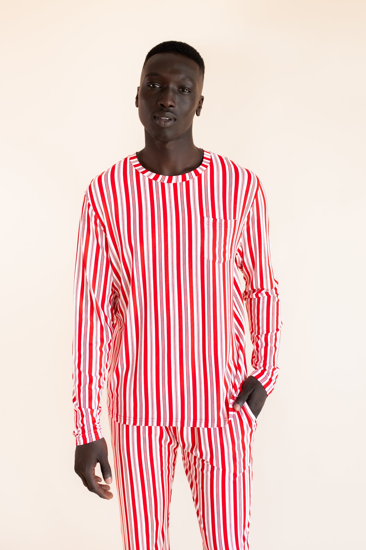 Modal wearing Men's Jogger Set in red and white Peppermint Stripes print on a  beige background