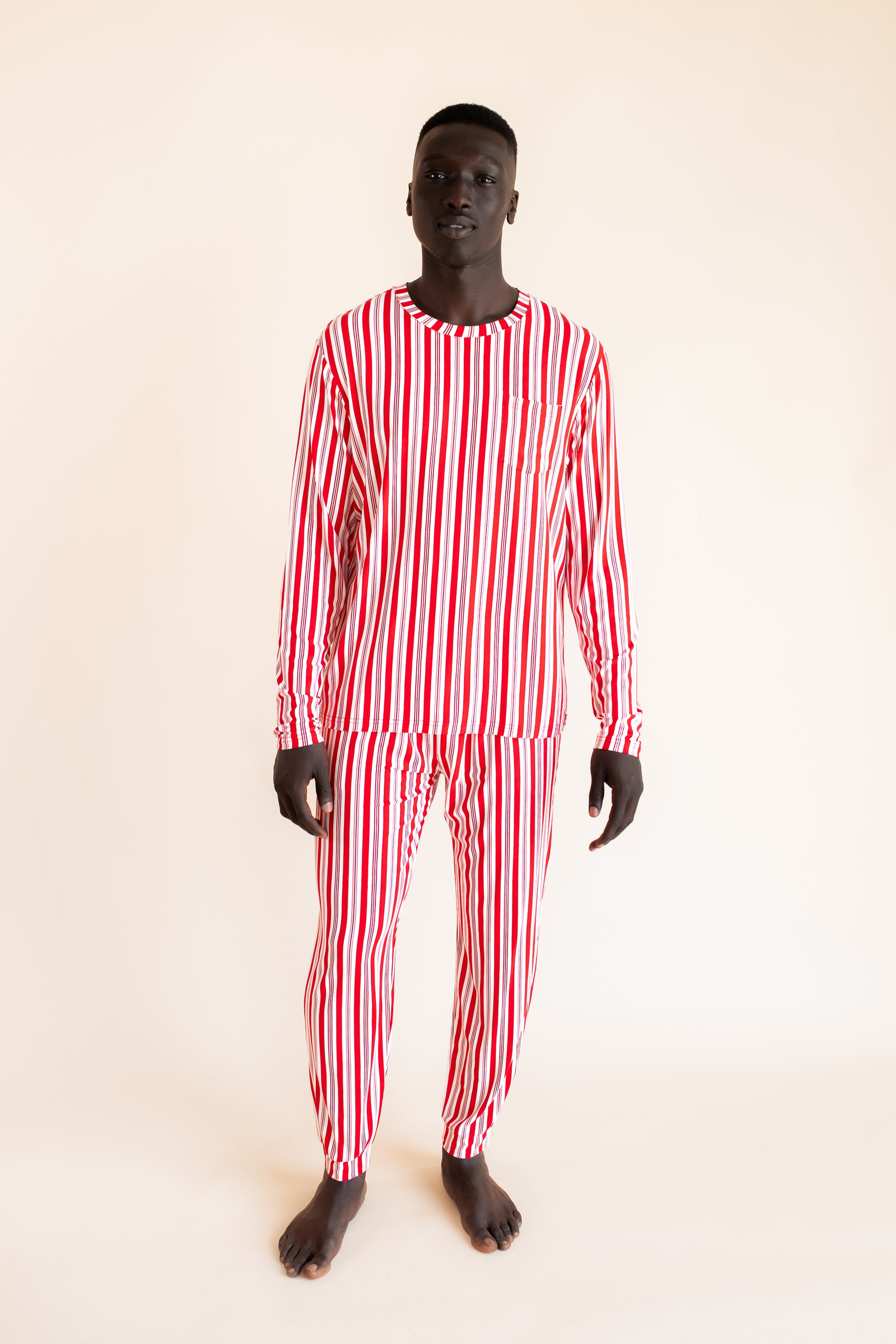Modal wearing Men's Jogger Set in red and white Peppermint Stripes print on a  beige background