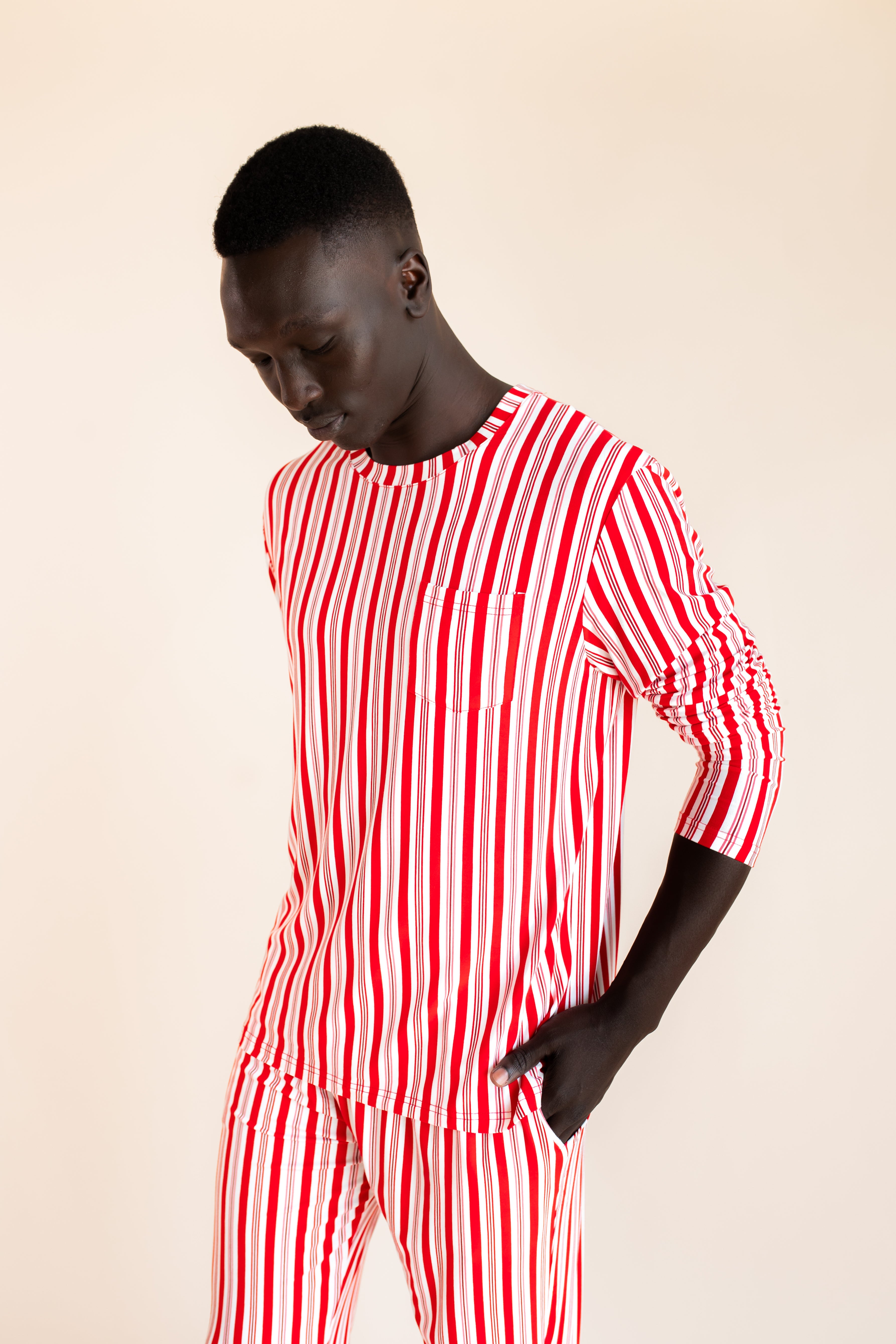 Modal wearing Men's Jogger Set in red and white Peppermint Stripes print on a  beige background