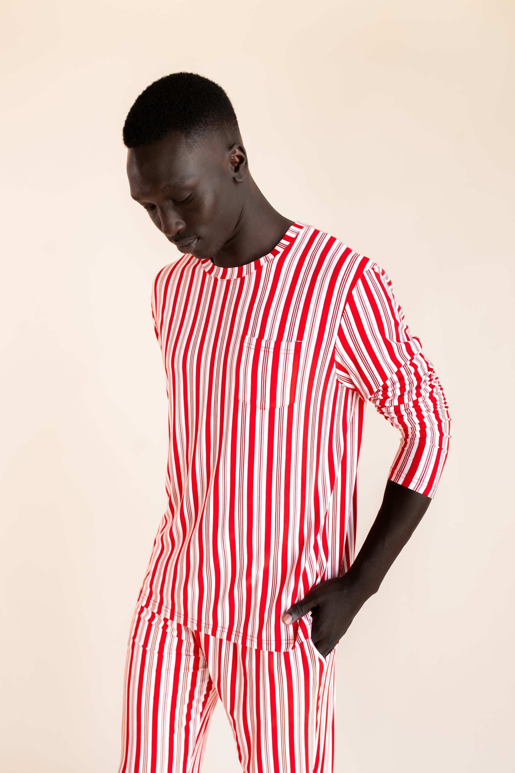 Modal wearing Men's Jogger Set in red and white Peppermint Stripes print on a  beige background