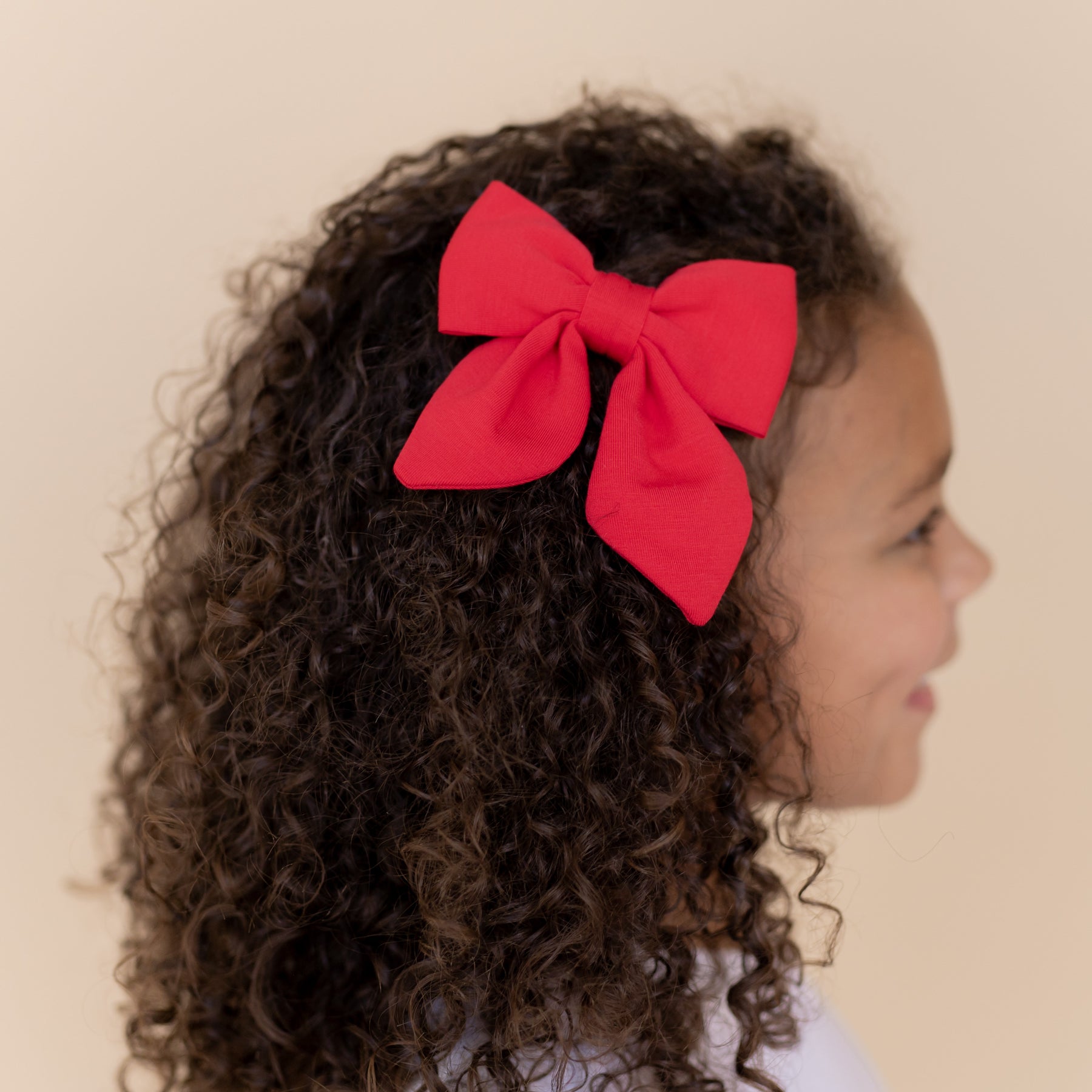 Medium Alligator Clip Bow in Cardinal shown in a young girls hair